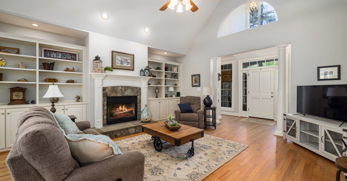 Cozy living room with fireplace, built-in bookshelves, wooden floor, and a doorway leading outside.