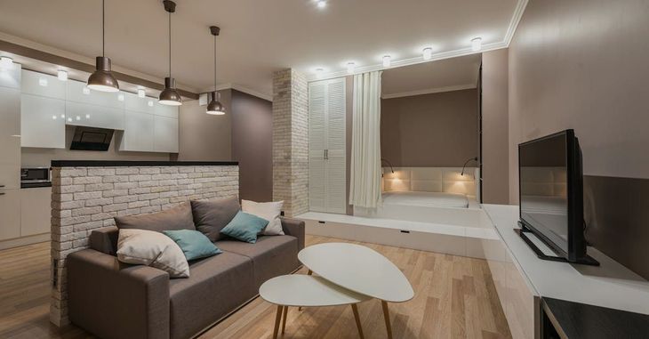 A living room with a couch , two coffee tables and a flat screen tv.