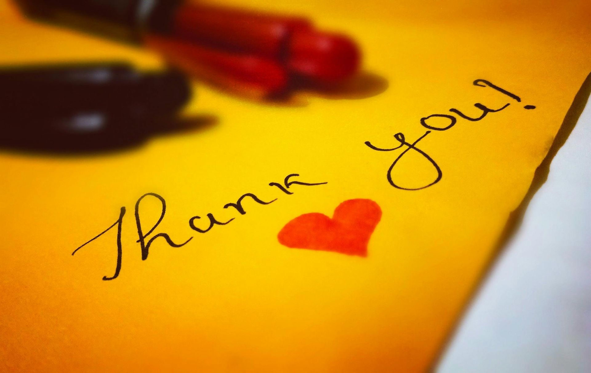 A thank you card with a red heart on it