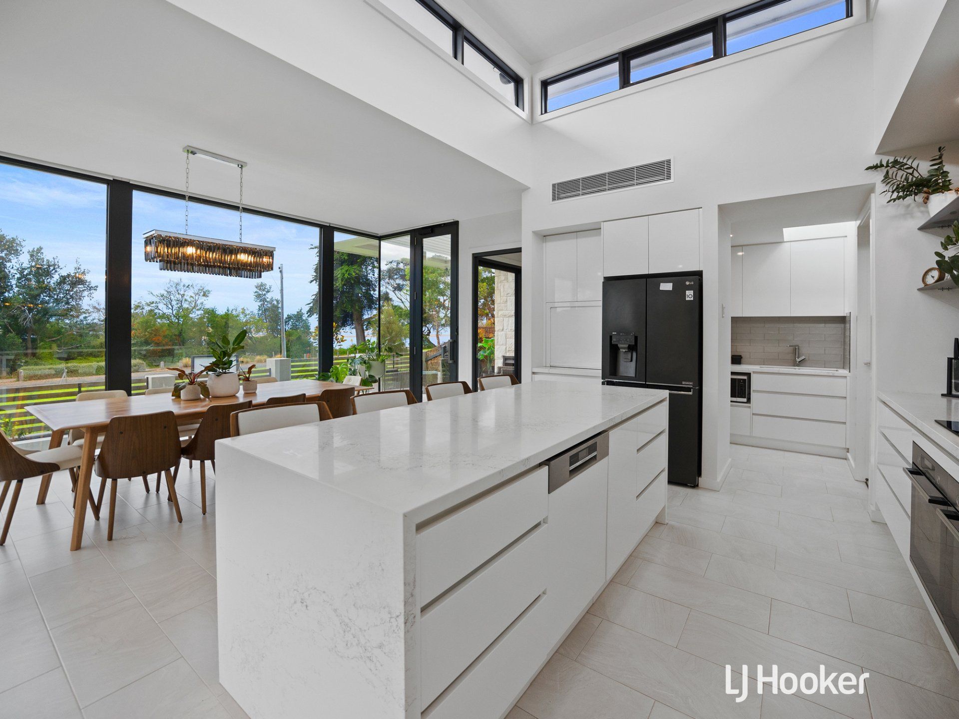 A kitchen with a large island and a black refrigerator