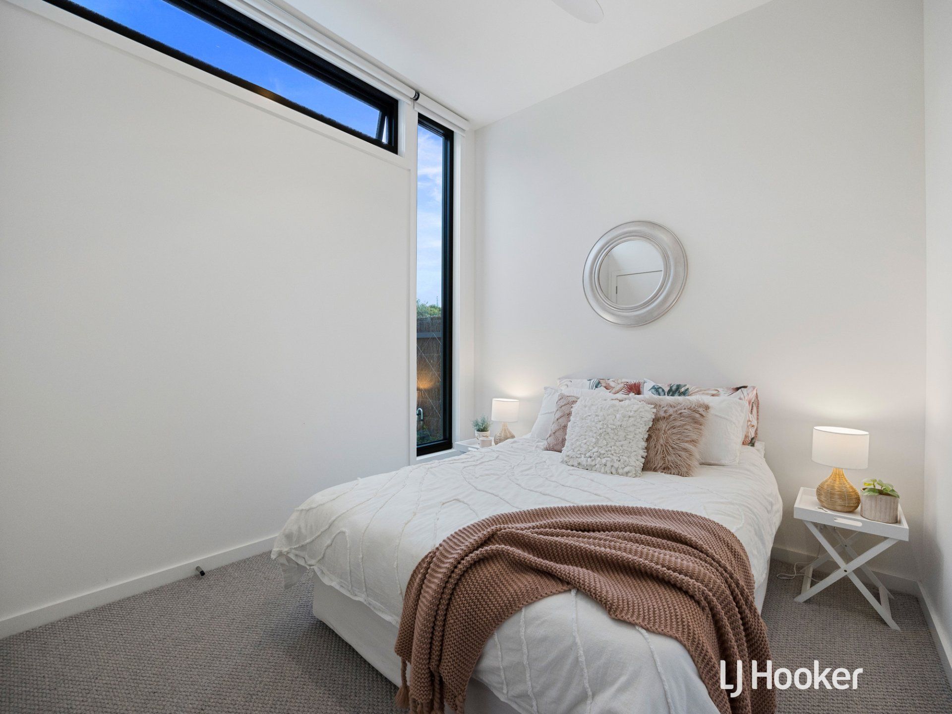 A bedroom with a bed and a mirror on the wall