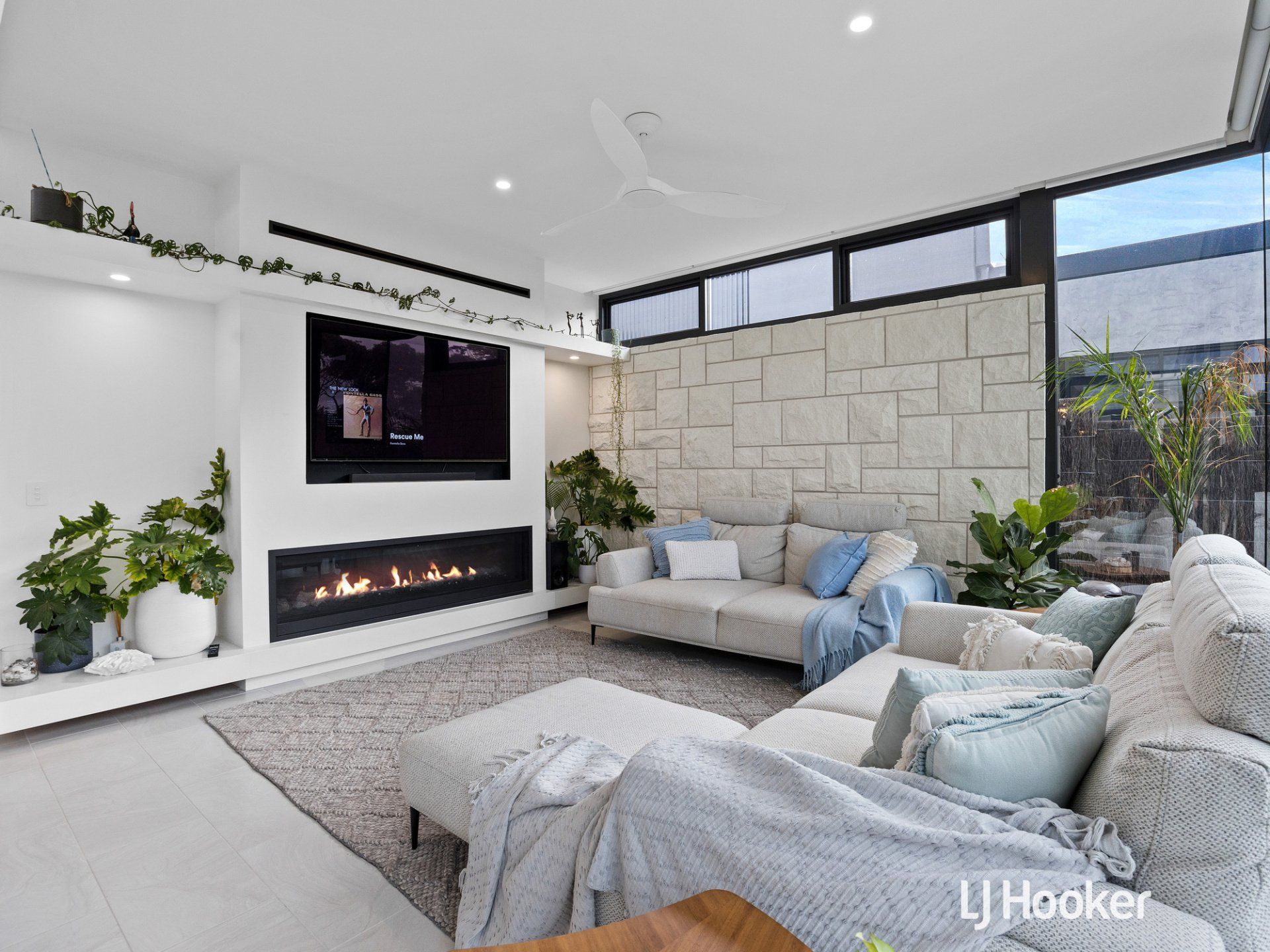 A living room with a couch , fireplace and television.