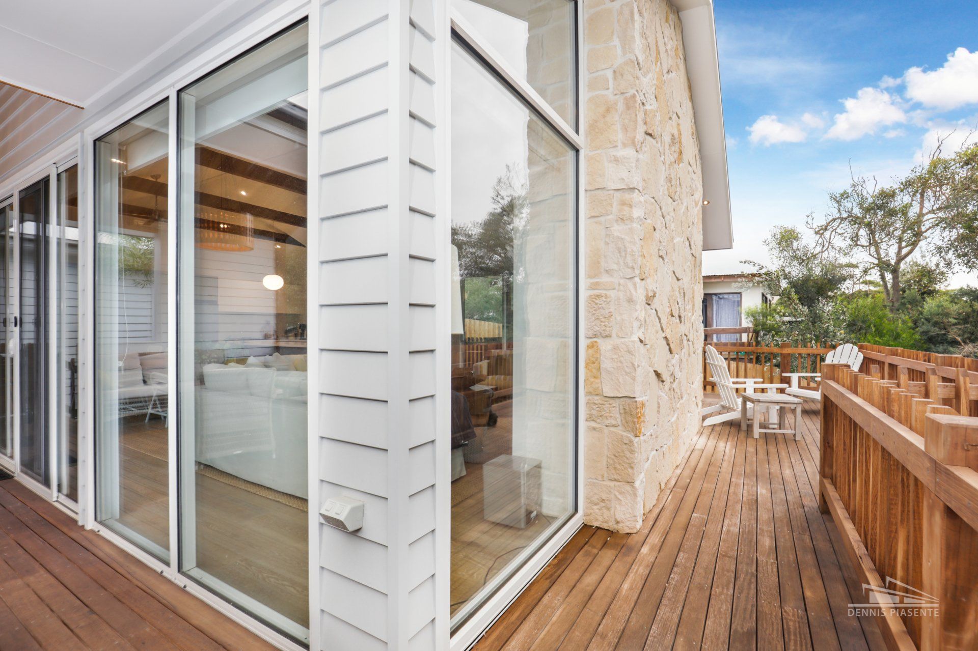 A house with a lot of windows and a wooden deck.