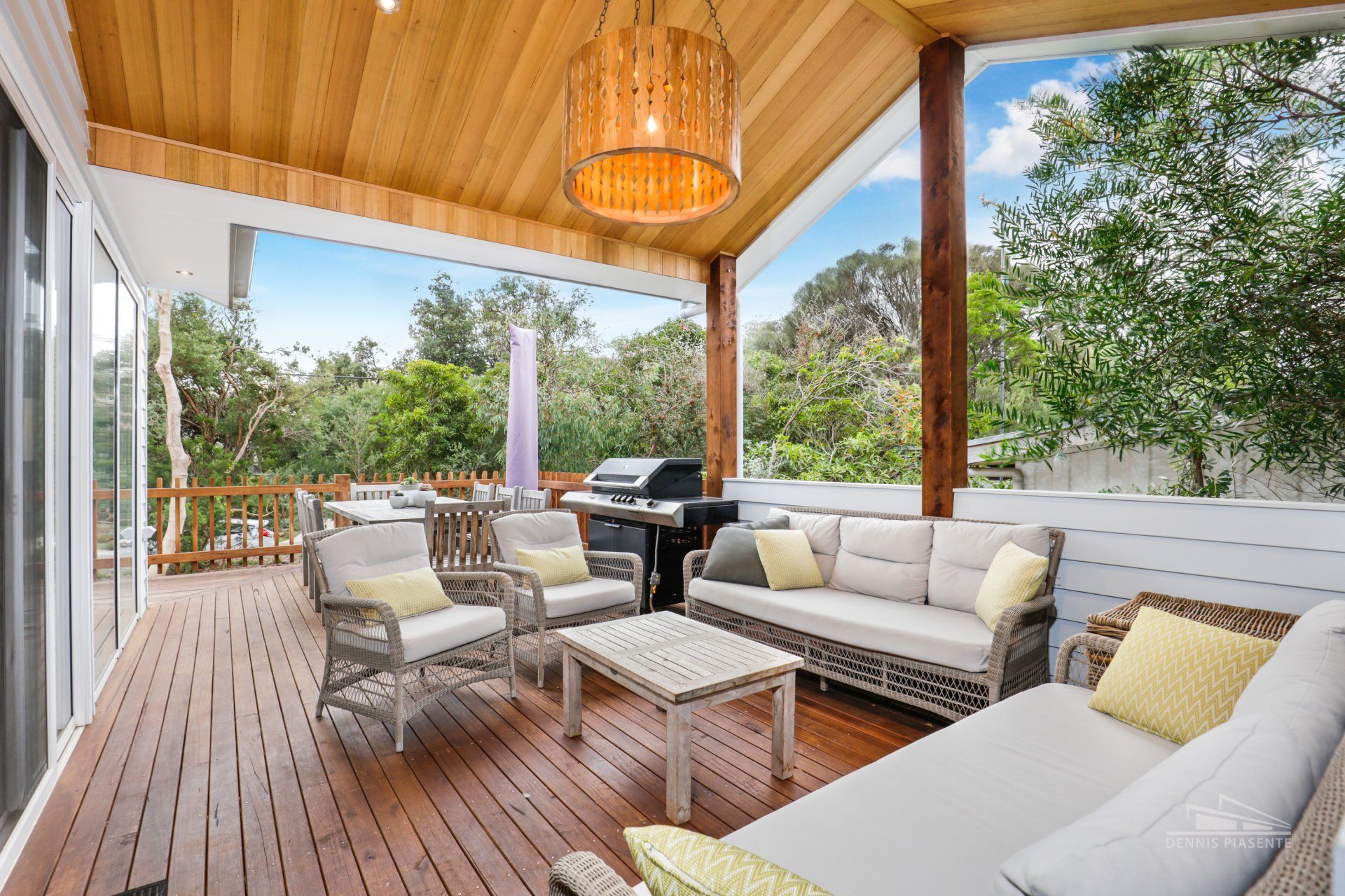 A wooden deck with a couch , chairs and a table