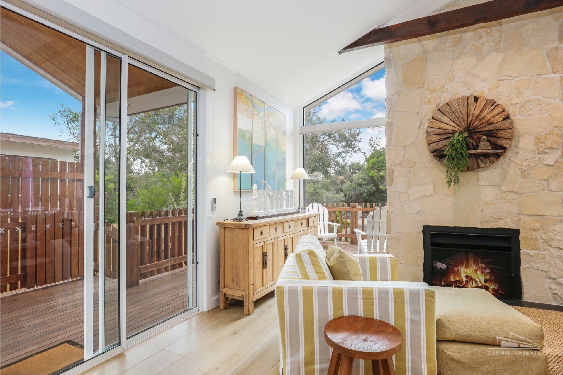 A living room with a couch , chair , fireplace and sliding glass doors.
