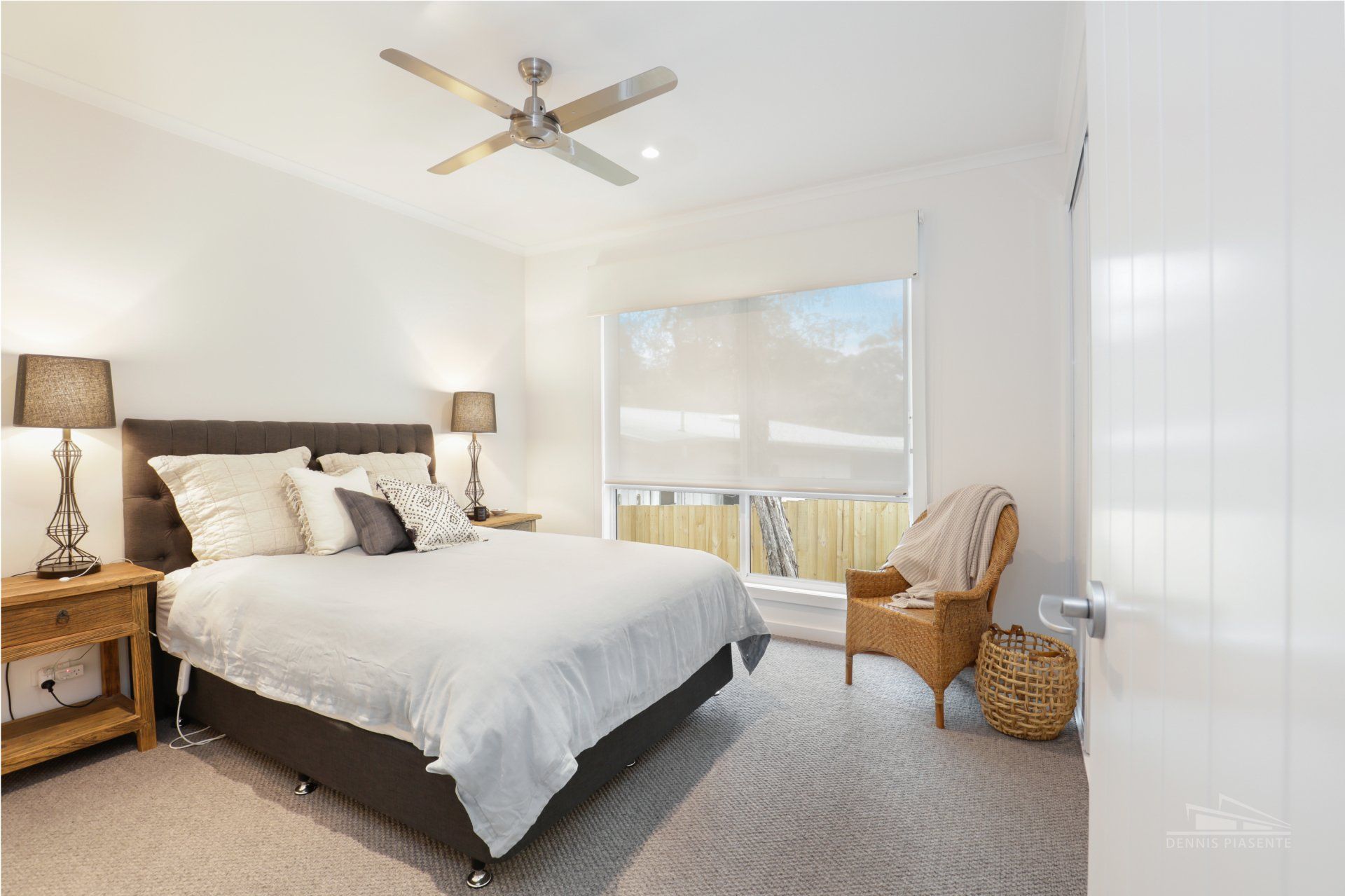A bedroom with a large bed and a ceiling fan.