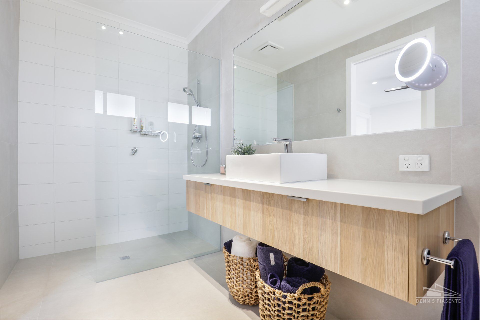 A bathroom with a sink , mirror and walk in shower.