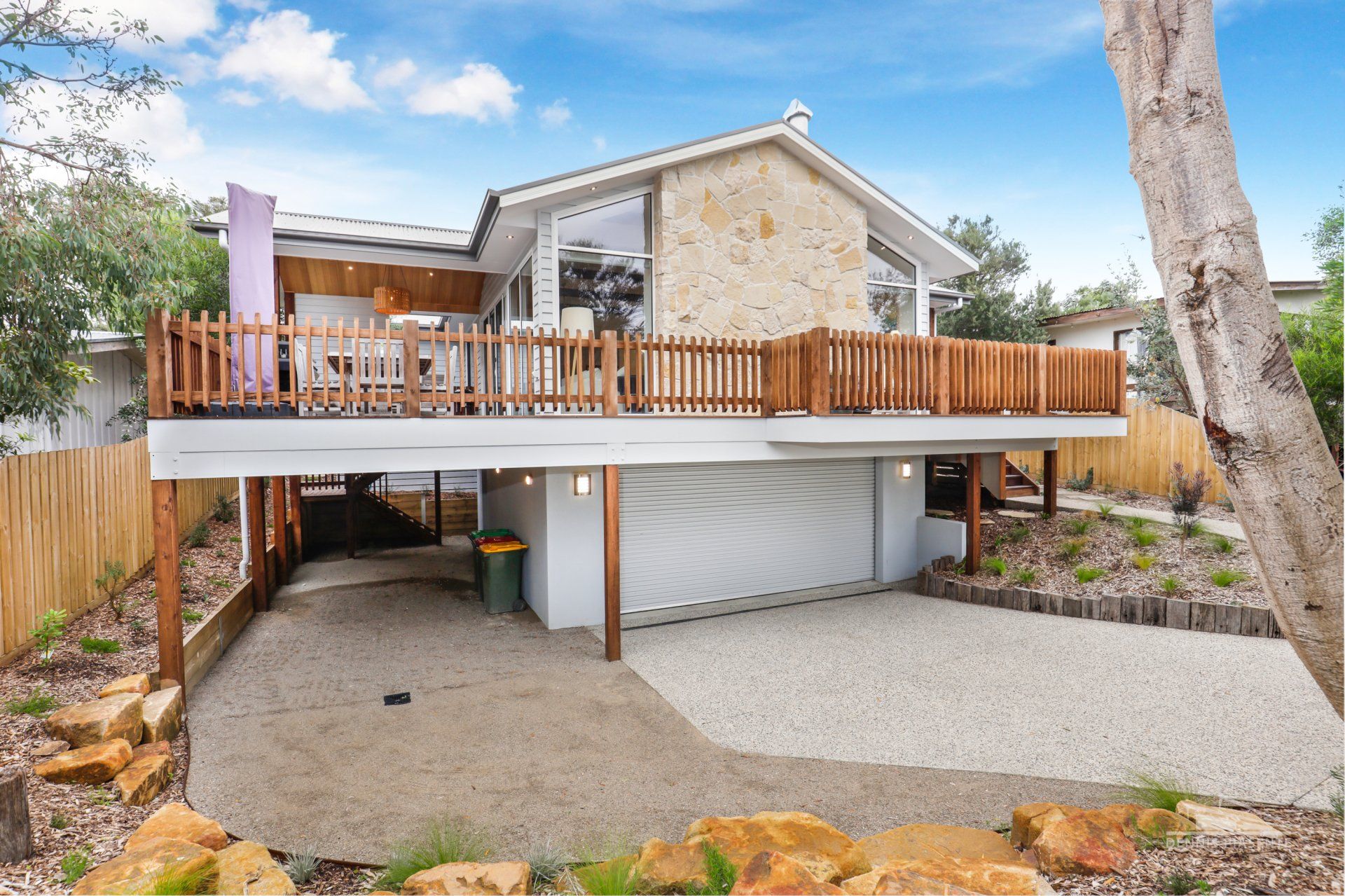 A large house with a large deck and a garage