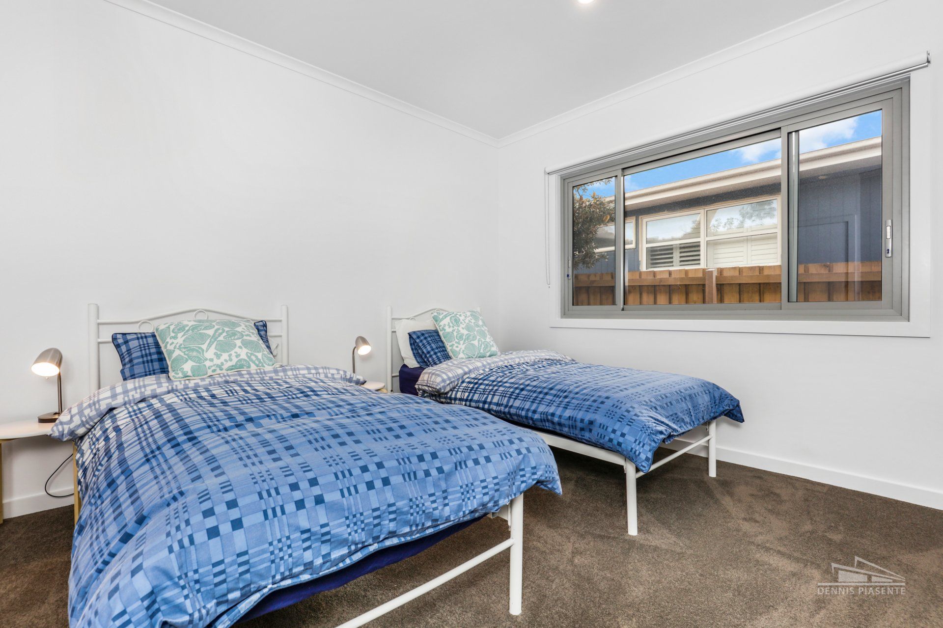A bedroom with two beds and a window.