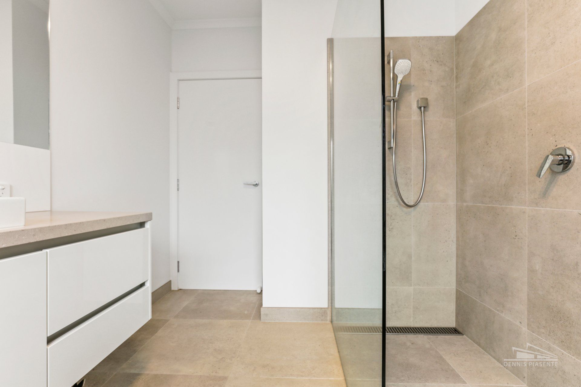 A bathroom with a walk in shower and a sink.