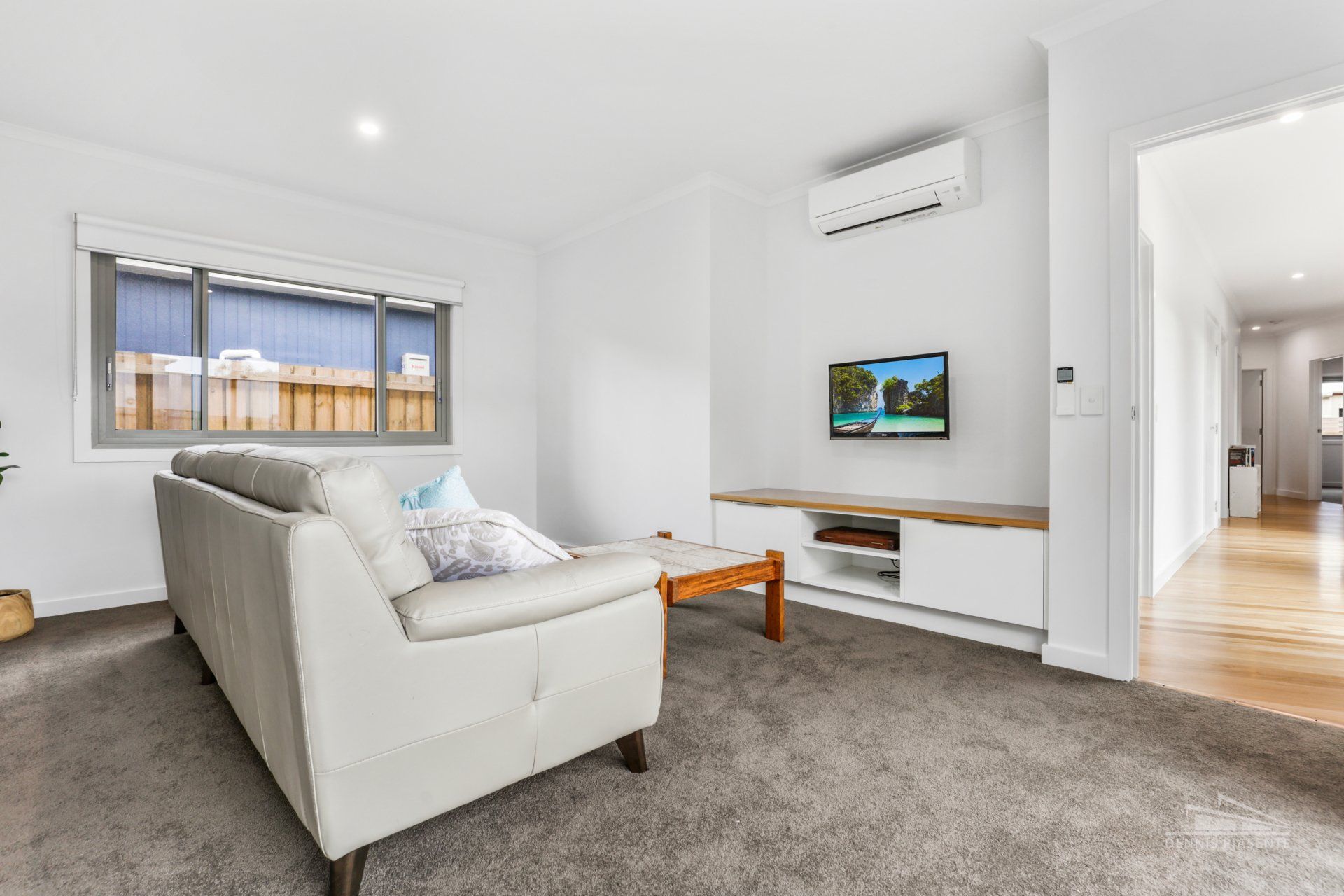 A living room with a couch , coffee table , and television.