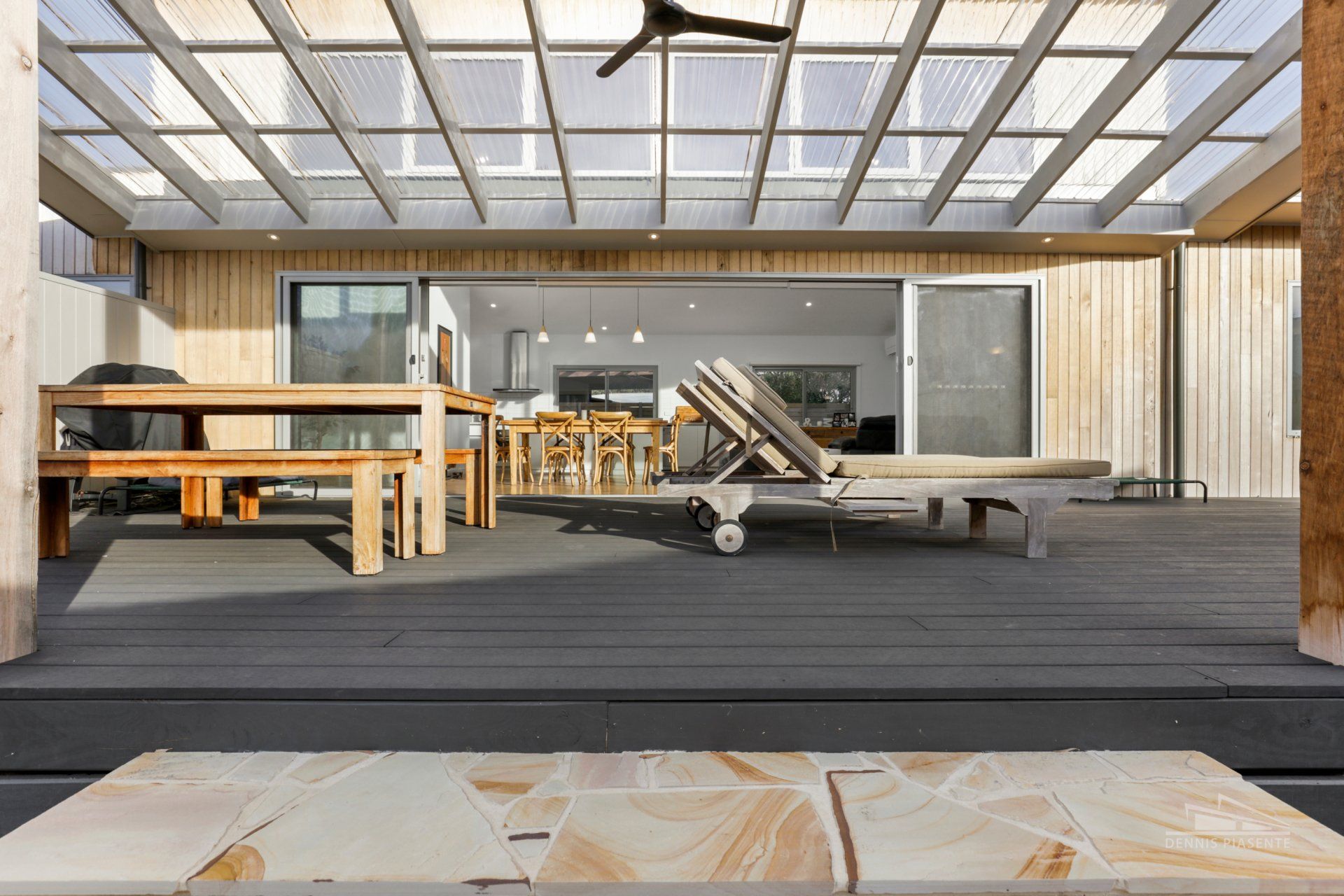 A patio with a table and chairs and a ceiling fan.