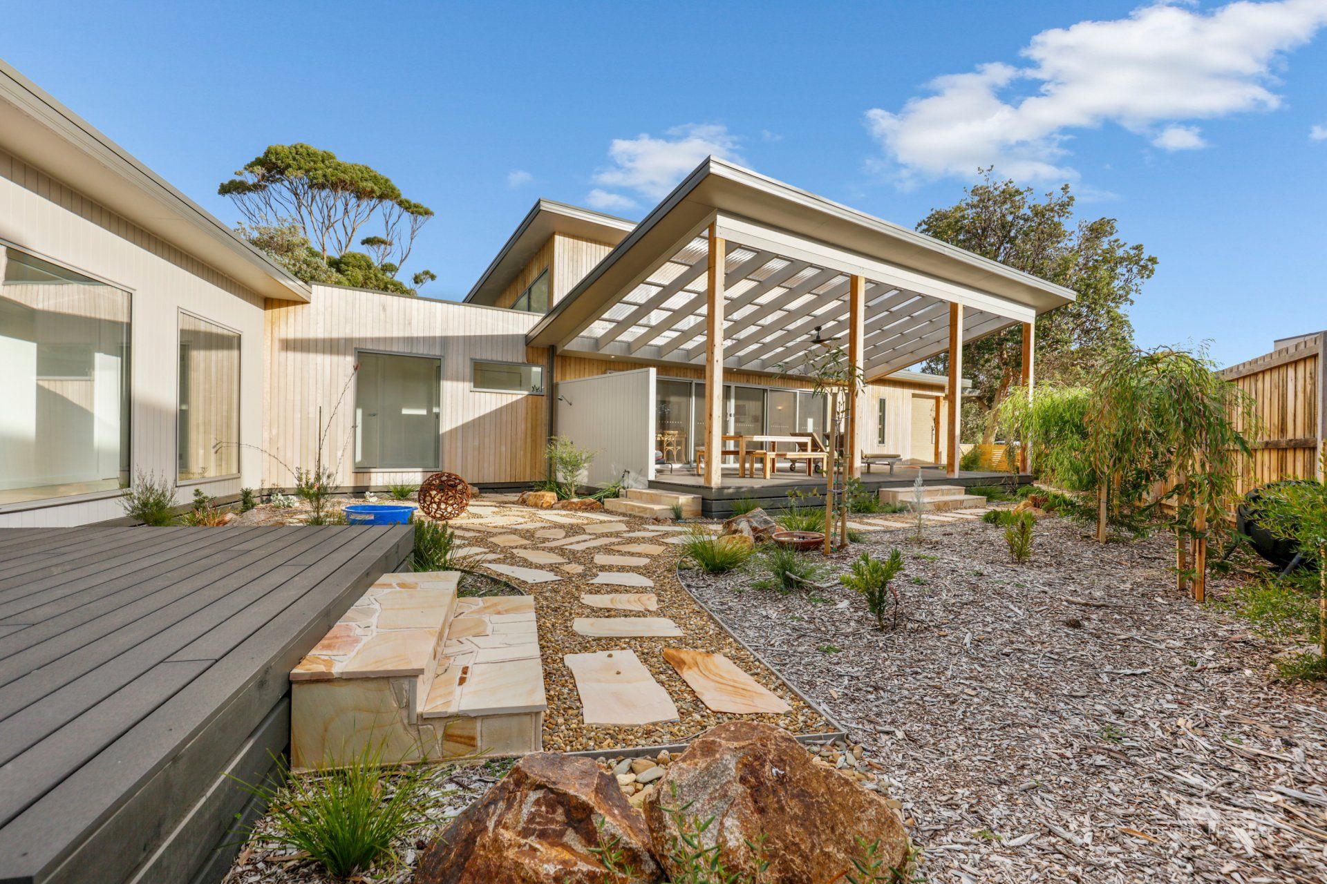 A house with a large deck and a pergola in the backyard.