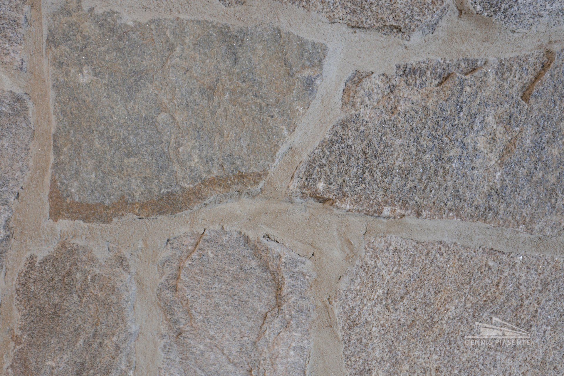 A close up of a stone wall with a few holes in it