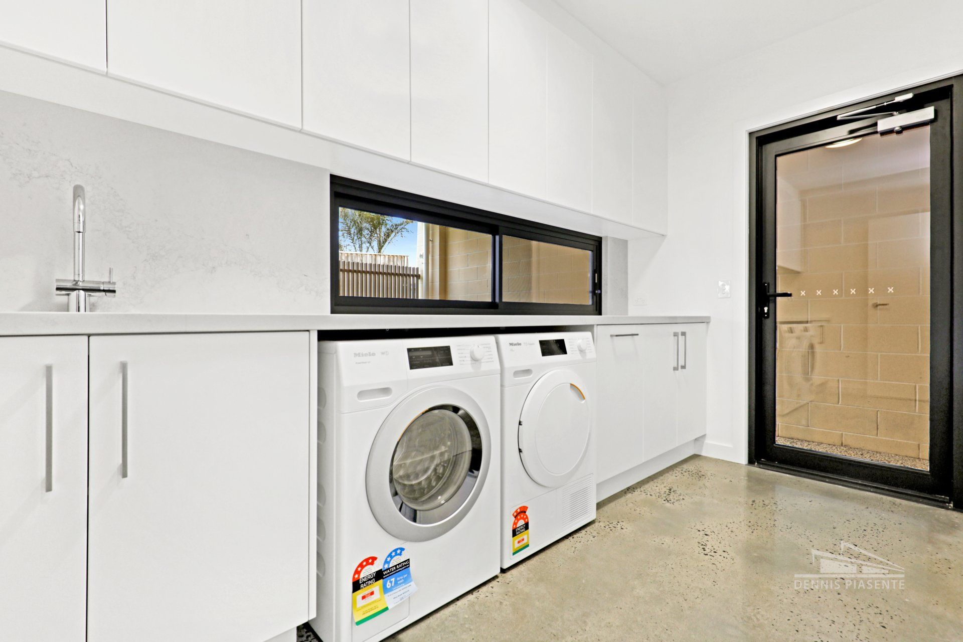 A laundry room with a washer and dryer and a sink.