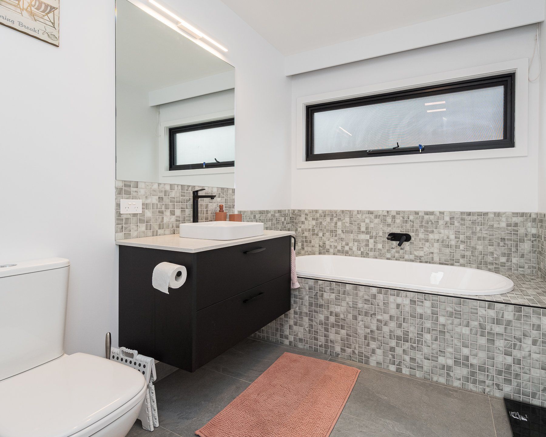 A bathroom with a toilet , sink , and bathtub.