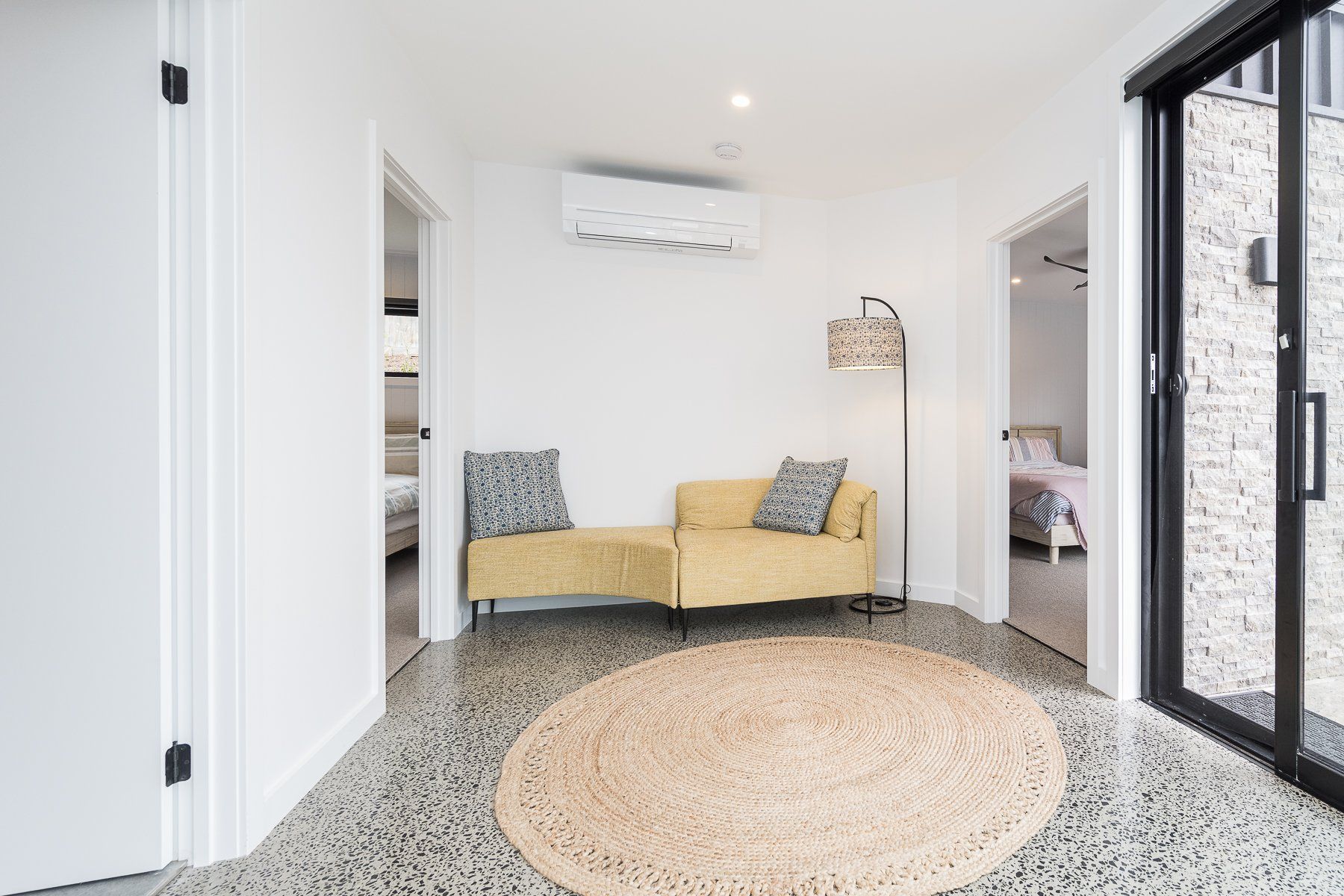 A living room with a yellow couch and a rug.