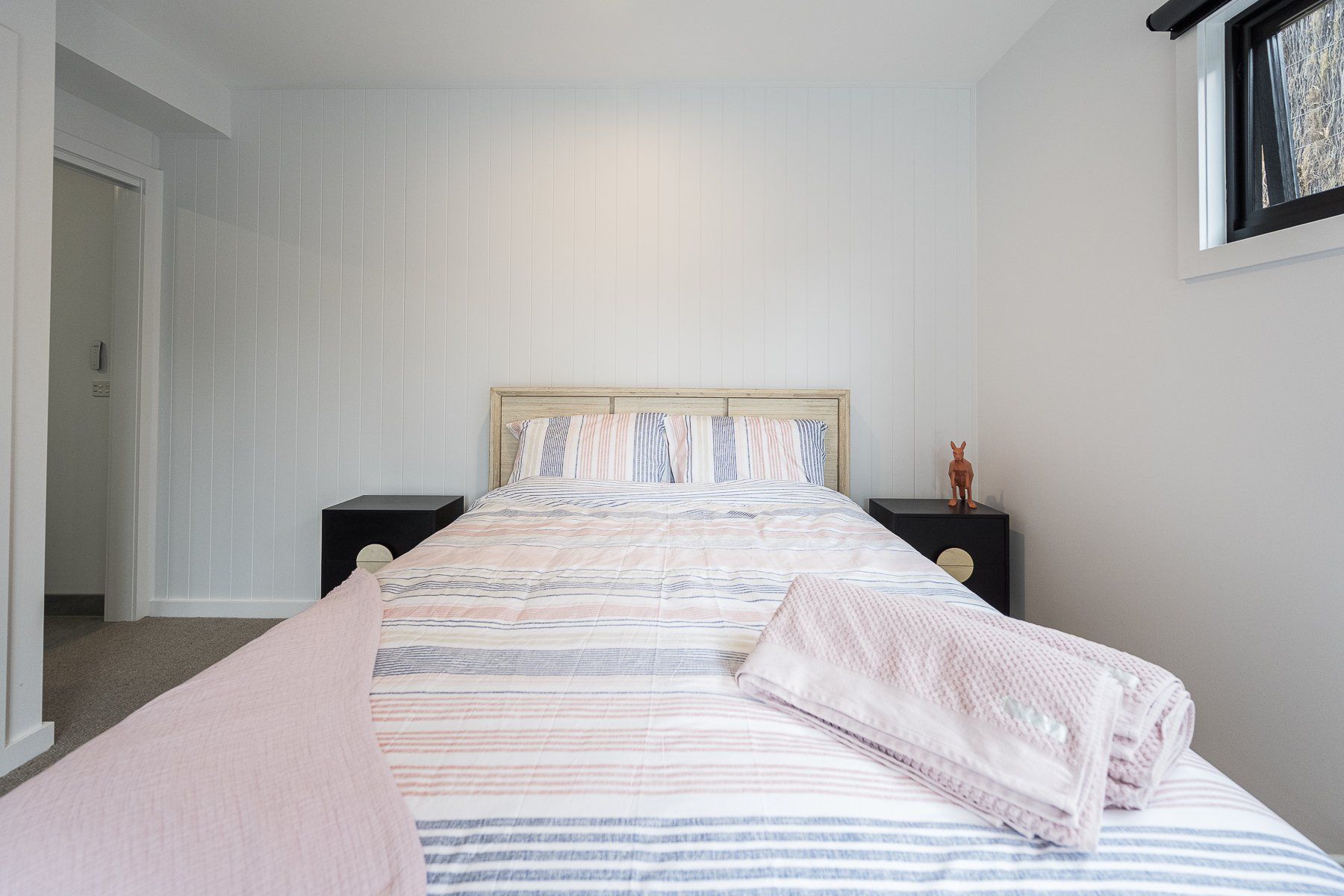 A bedroom with a bed , nightstand , and window.