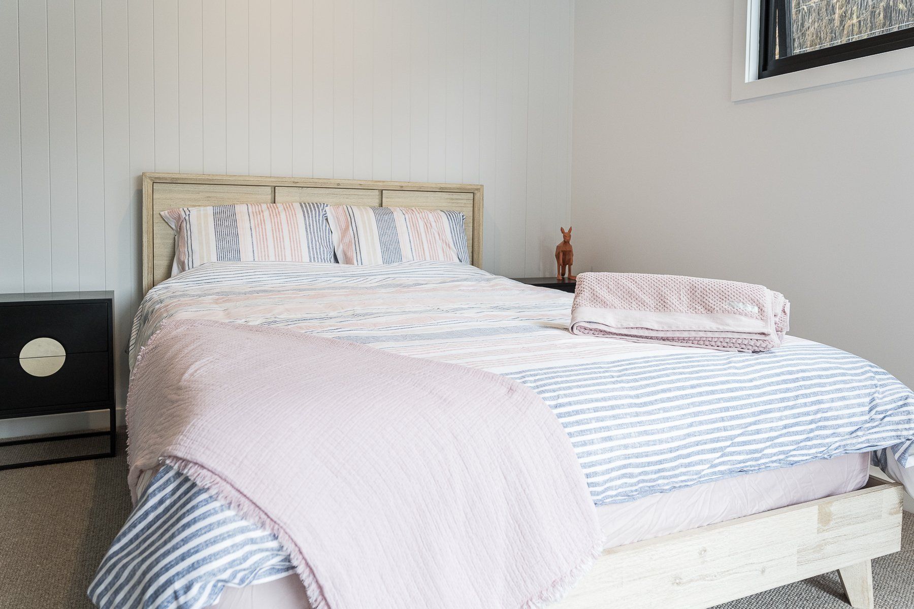 A bedroom with a bed , nightstand , and window.