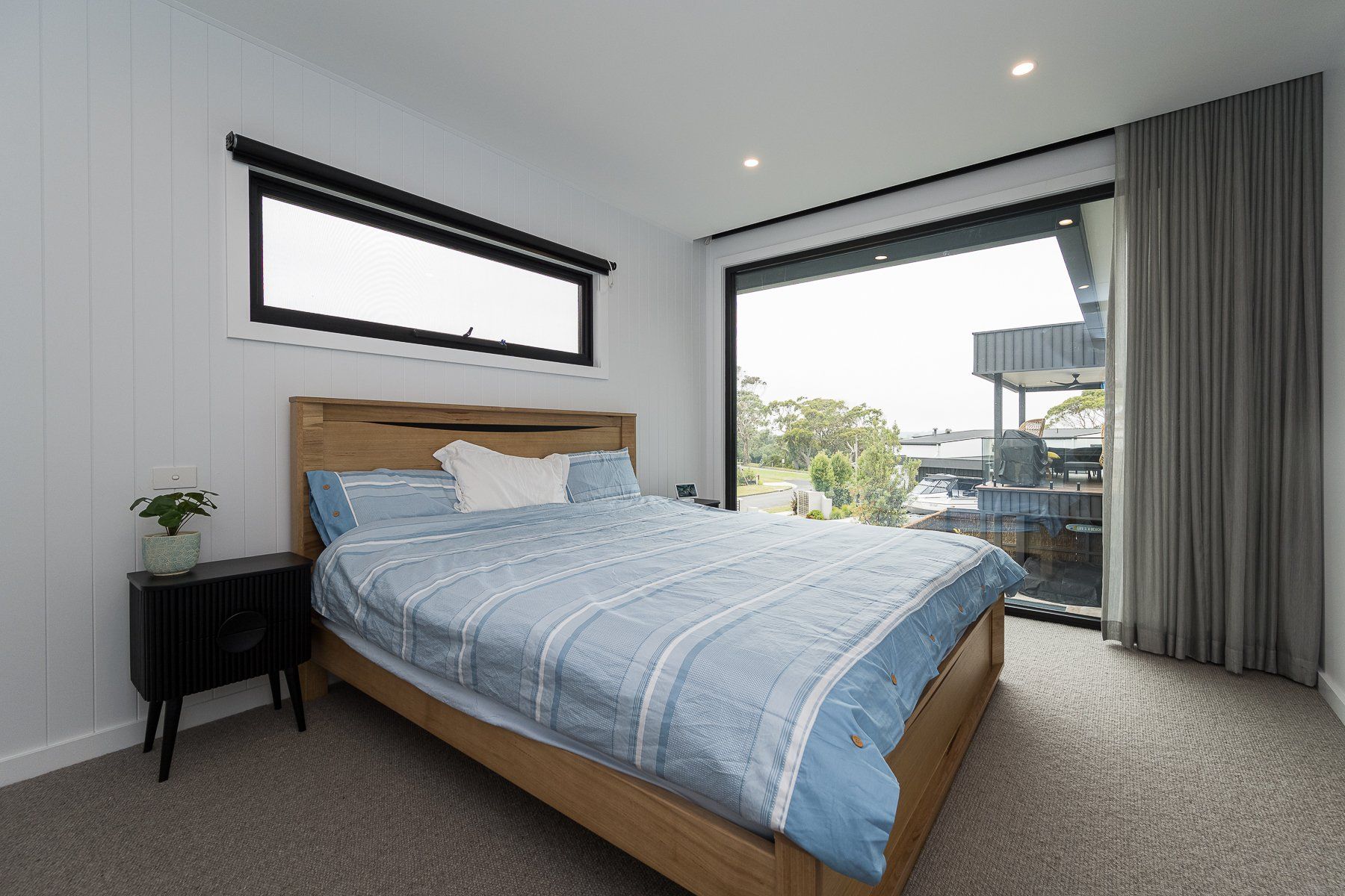 A bedroom with a large bed and a large window.