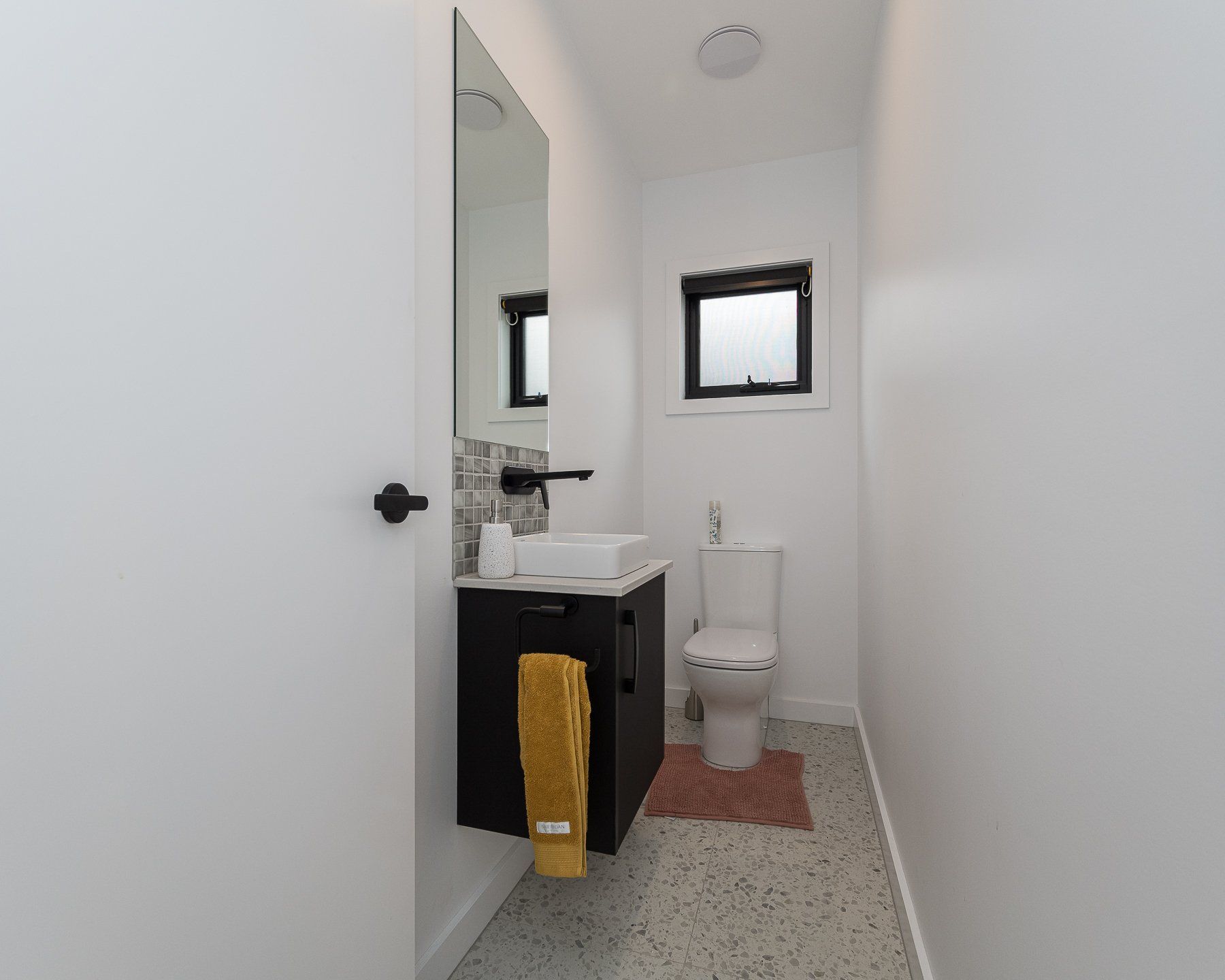 A bathroom with a sink , toilet and mirror.