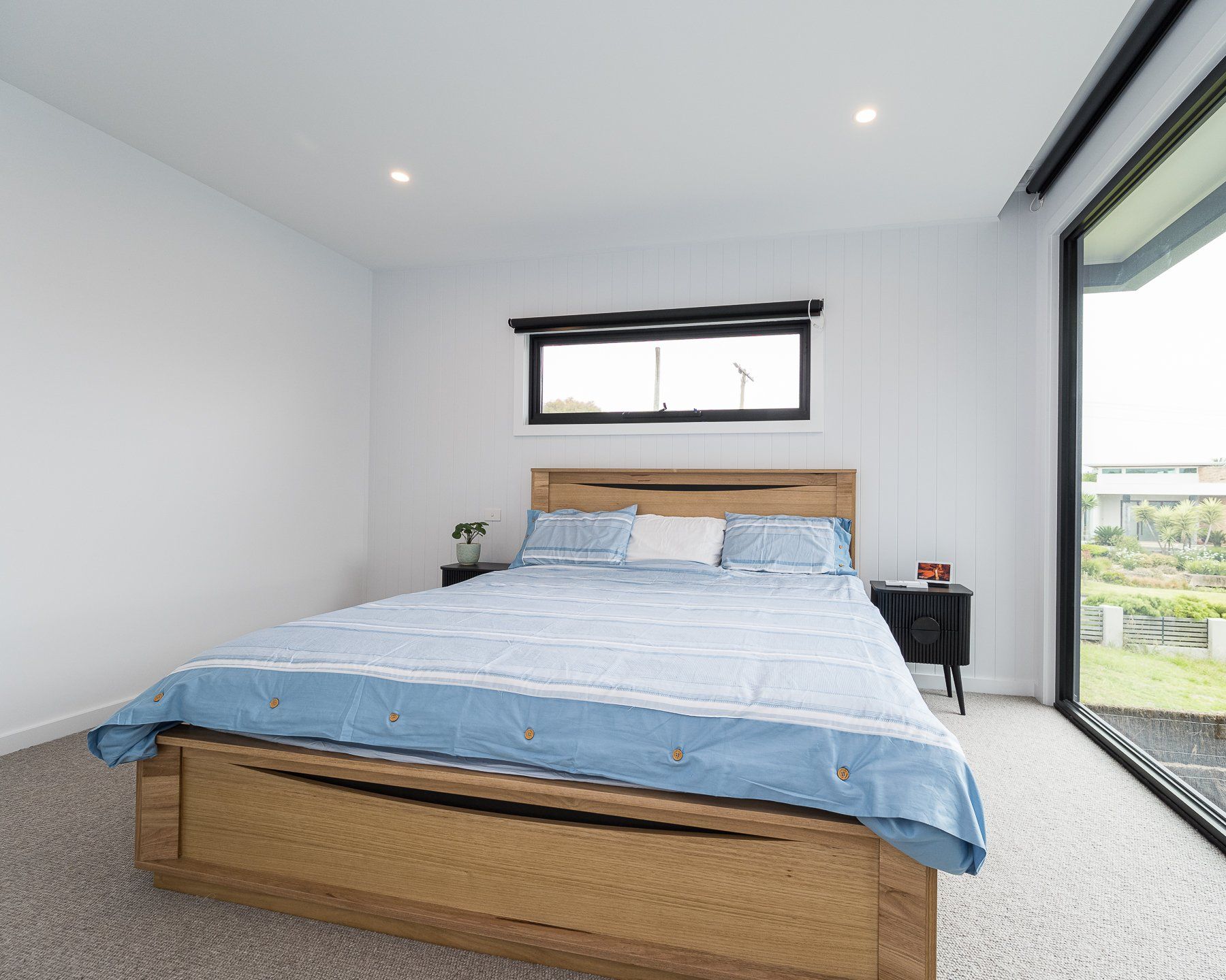 A bedroom with a large bed and a sliding glass door.