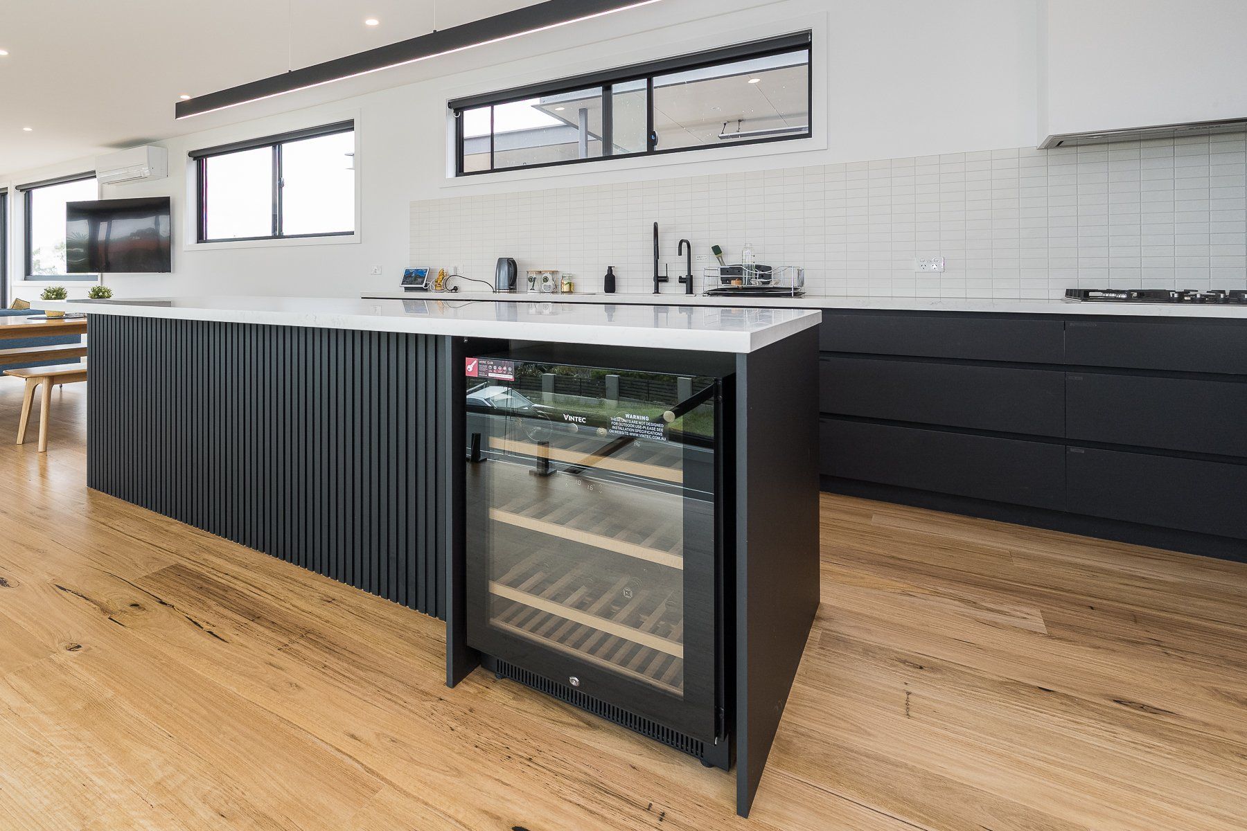 There is a wine cooler in the middle of the kitchen.