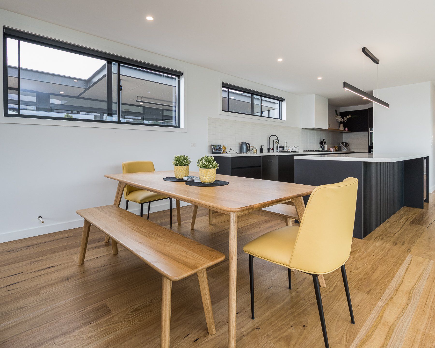 A dining room with a table and chairs and a bench.