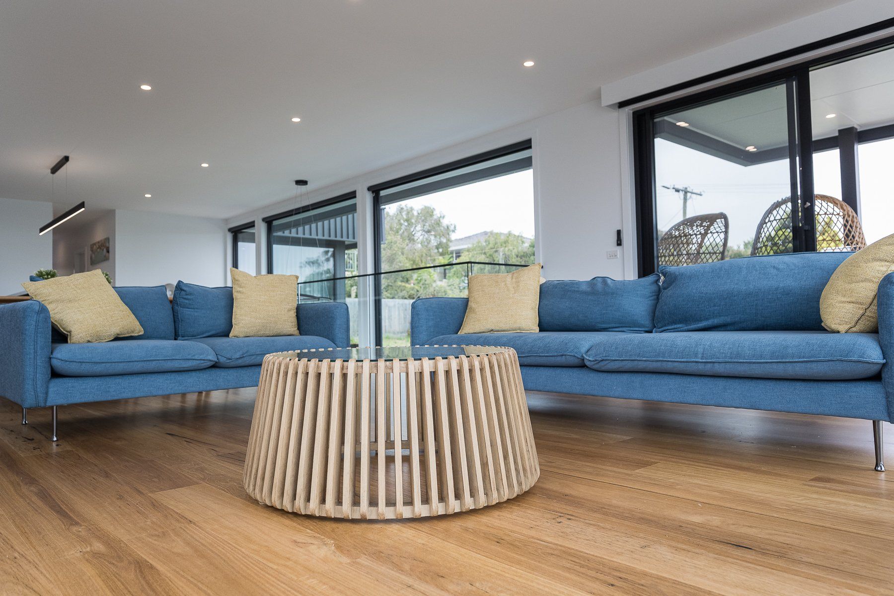 A living room with two blue couches and a round coffee table.