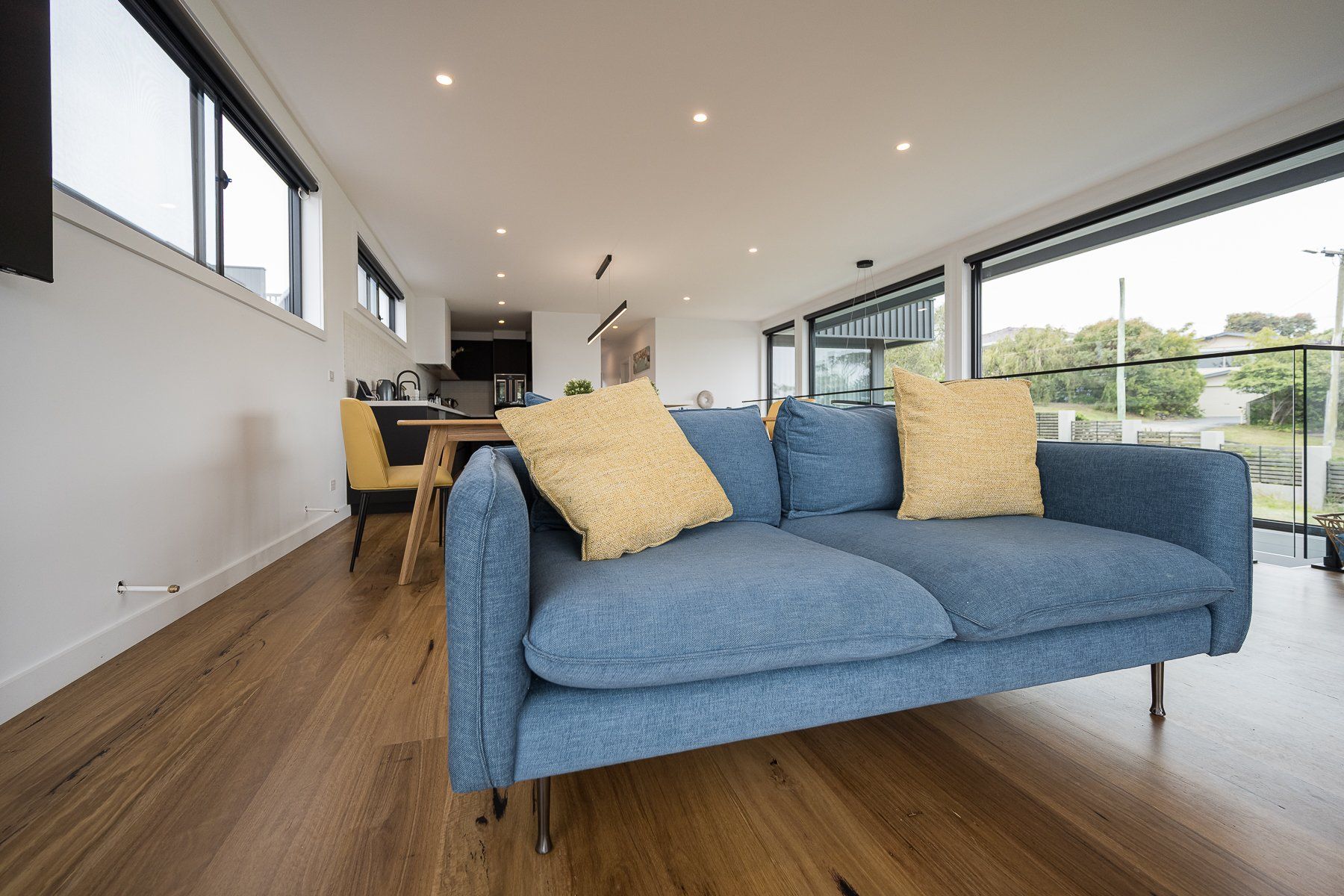 A blue couch with yellow pillows is sitting in a living room.