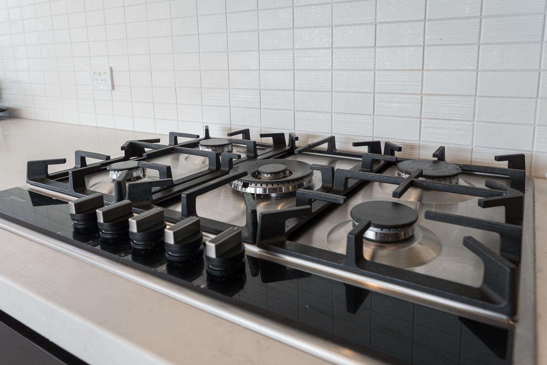 A gas stove is sitting on top of a counter in a kitchen.