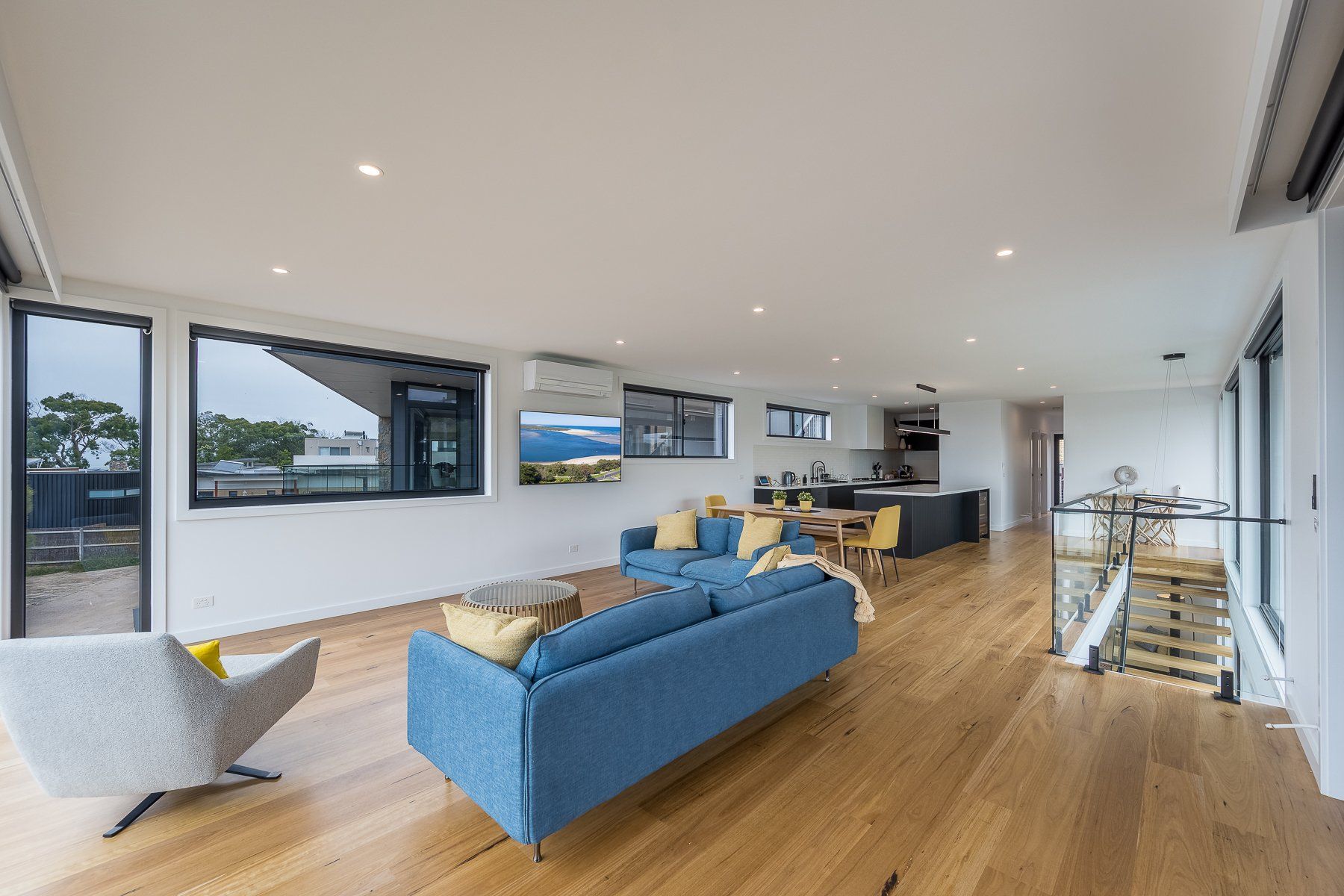 A living room with a blue couch and a white chair.