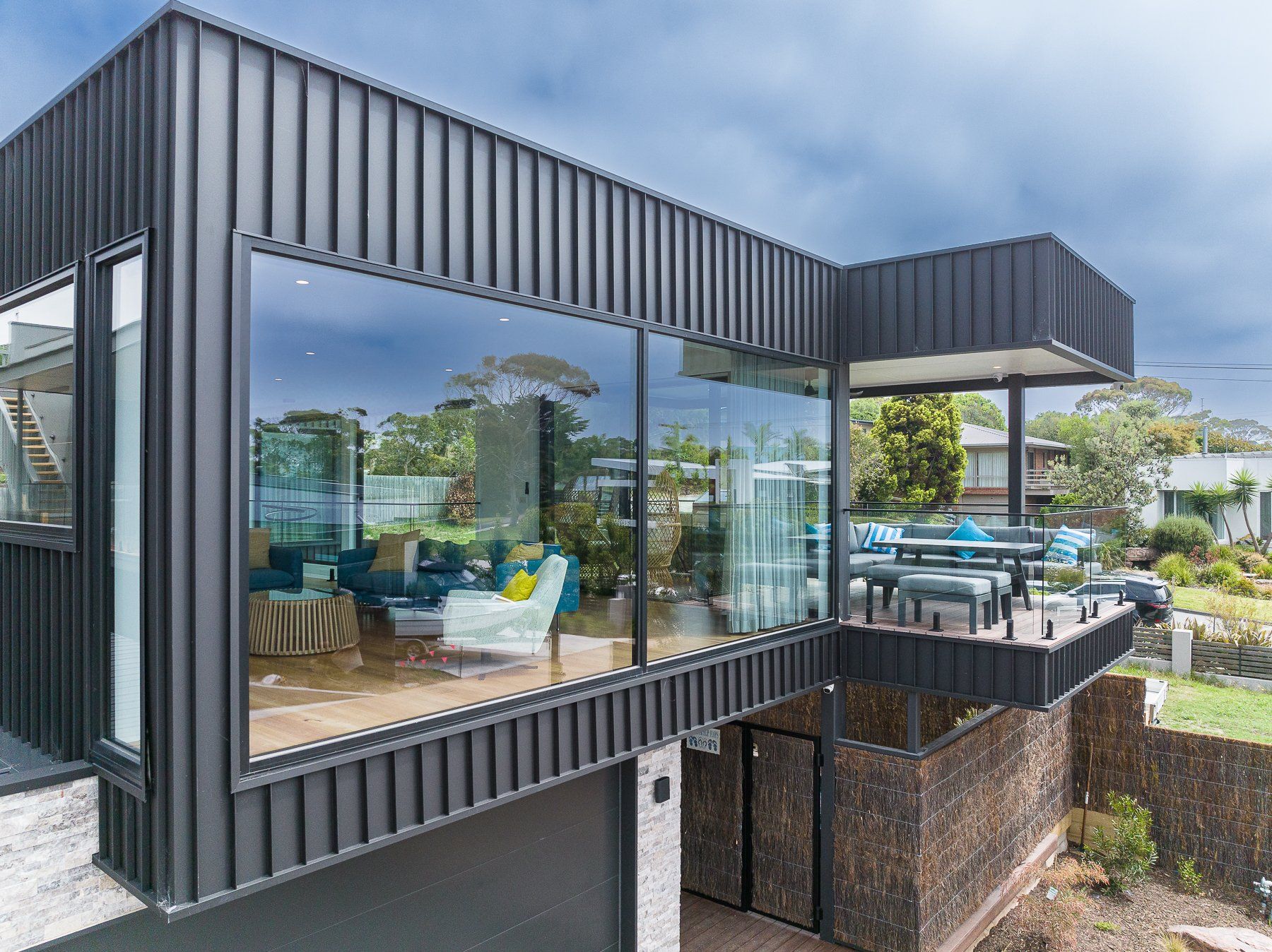 A modern house with a lot of windows and a balcony.