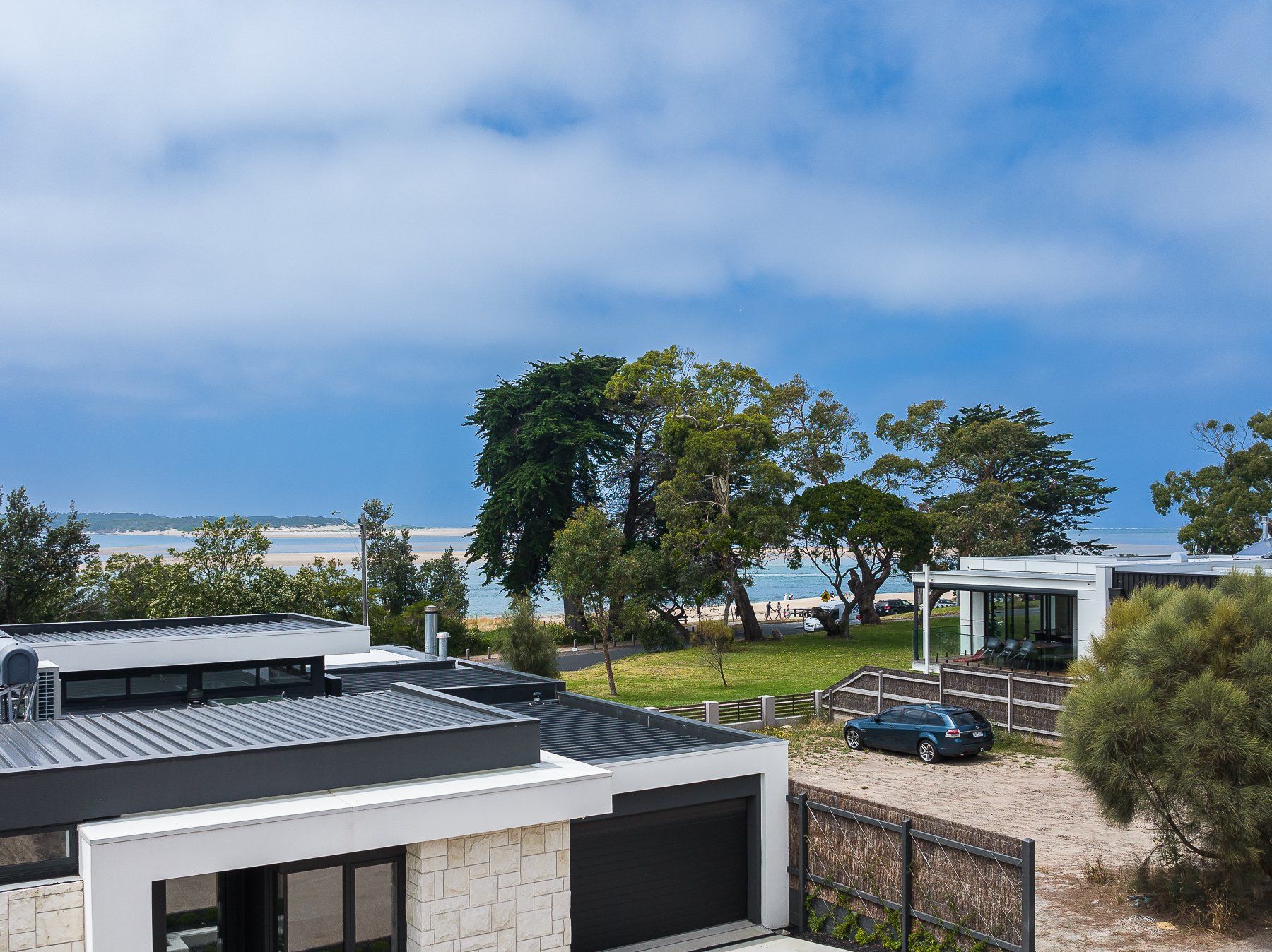 An aerial view of a house with a car parked in front of it