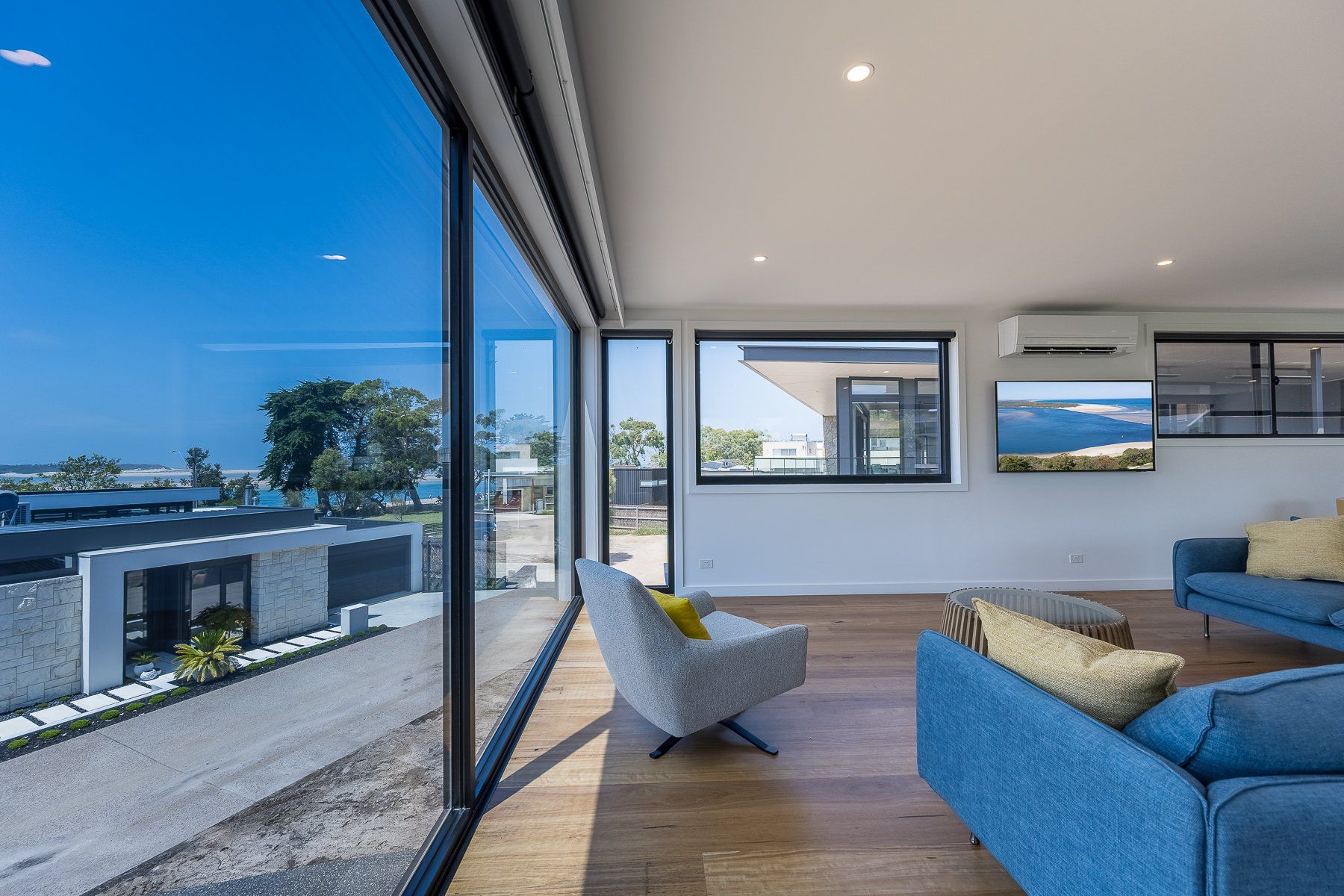 A living room with a couch , chair , and large windows.