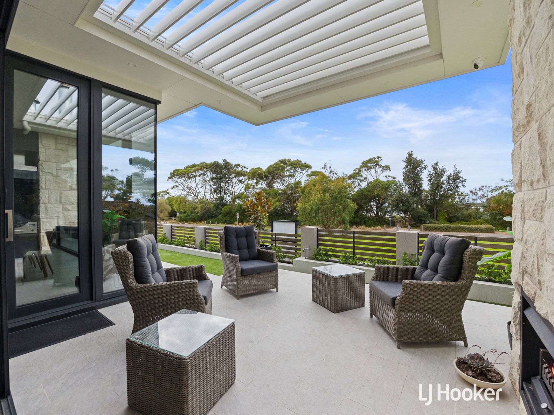 A patio with chairs and tables under a roof.