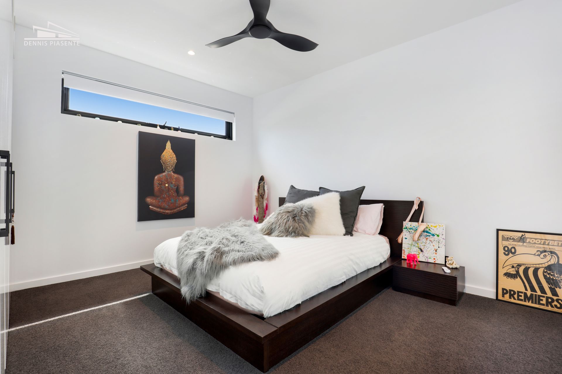 A bedroom with a large bed and a ceiling fan.