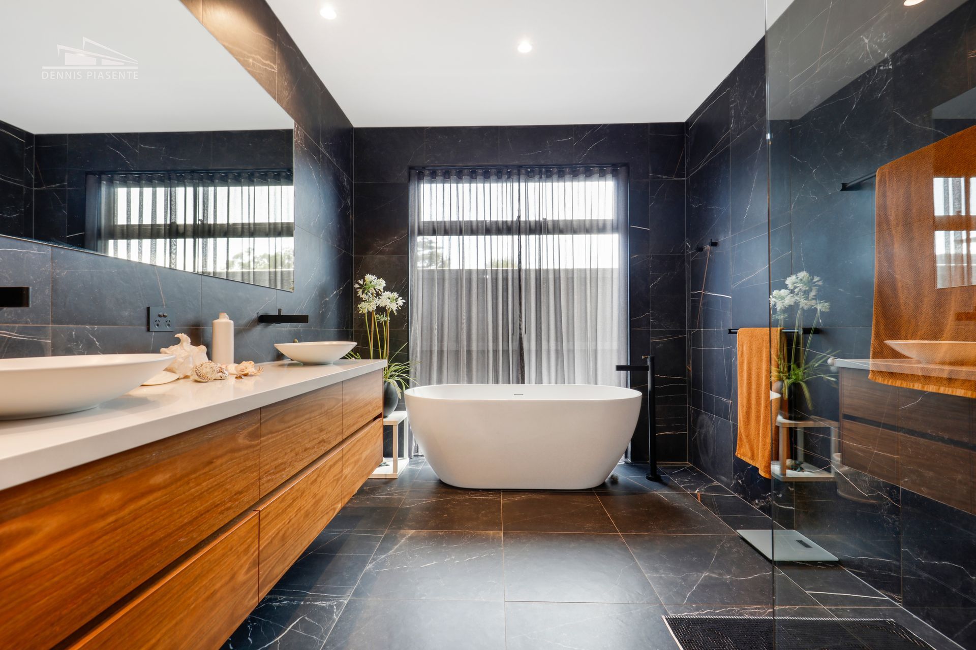 A bathroom with a bathtub , sinks , and a walk in shower.