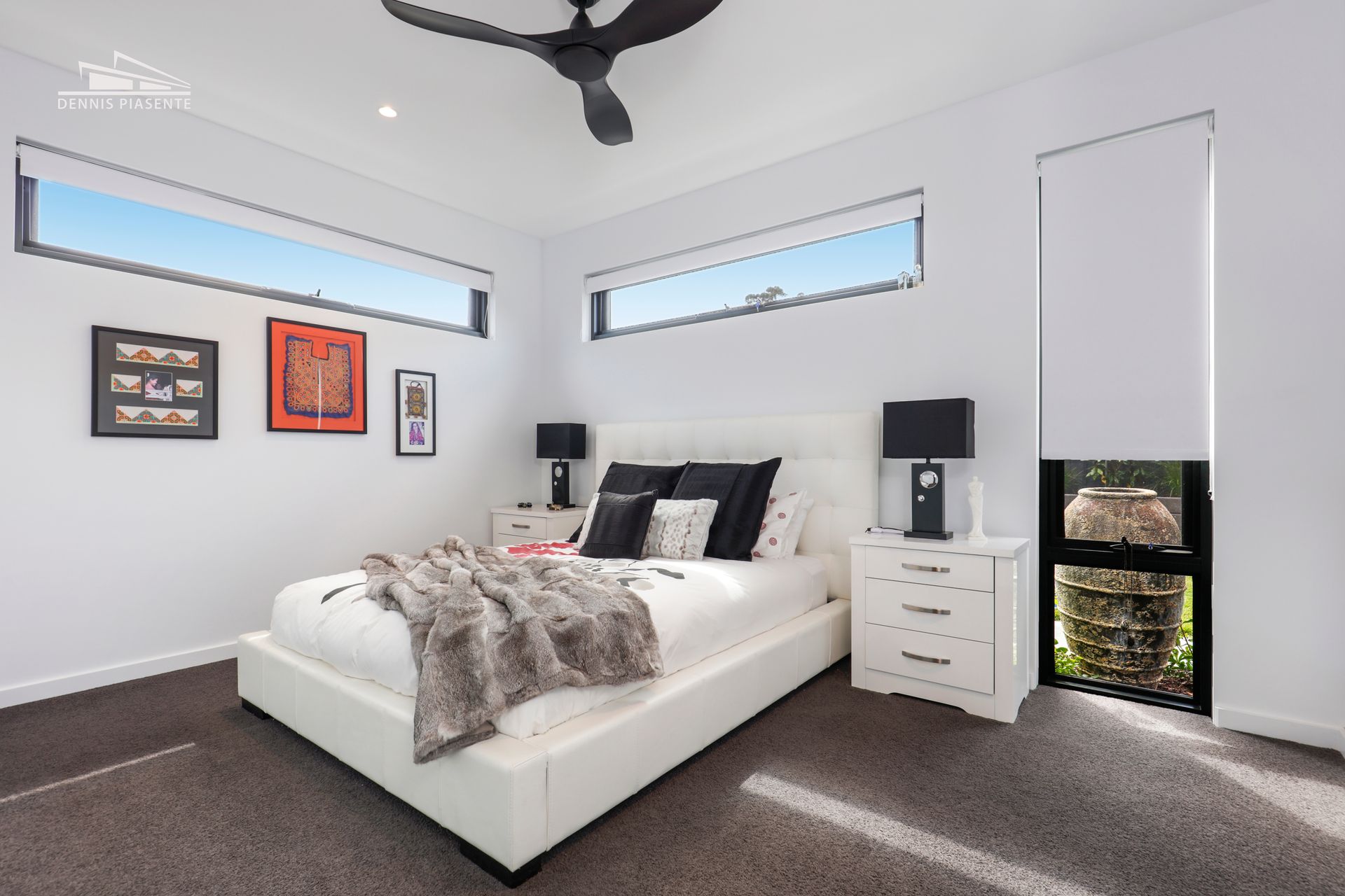 A bedroom with a large bed and a ceiling fan