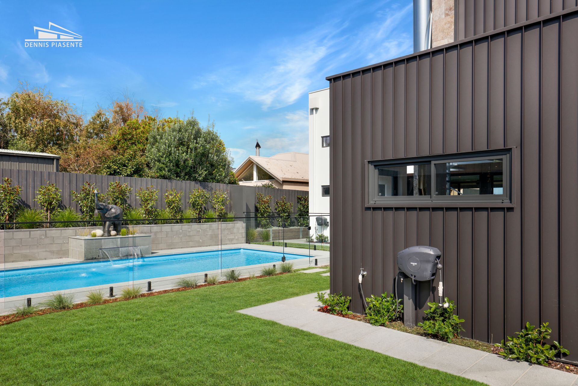 There is a large swimming pool in the backyard of a house.