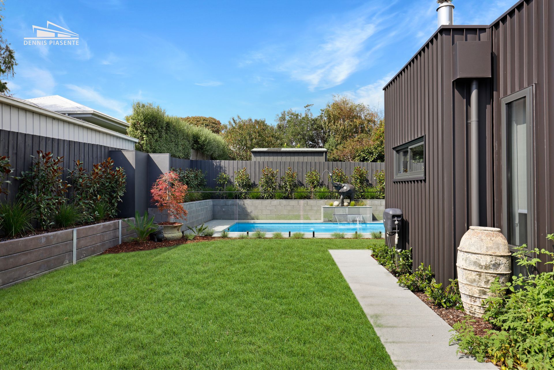 There is a swimming pool in the backyard of a house.