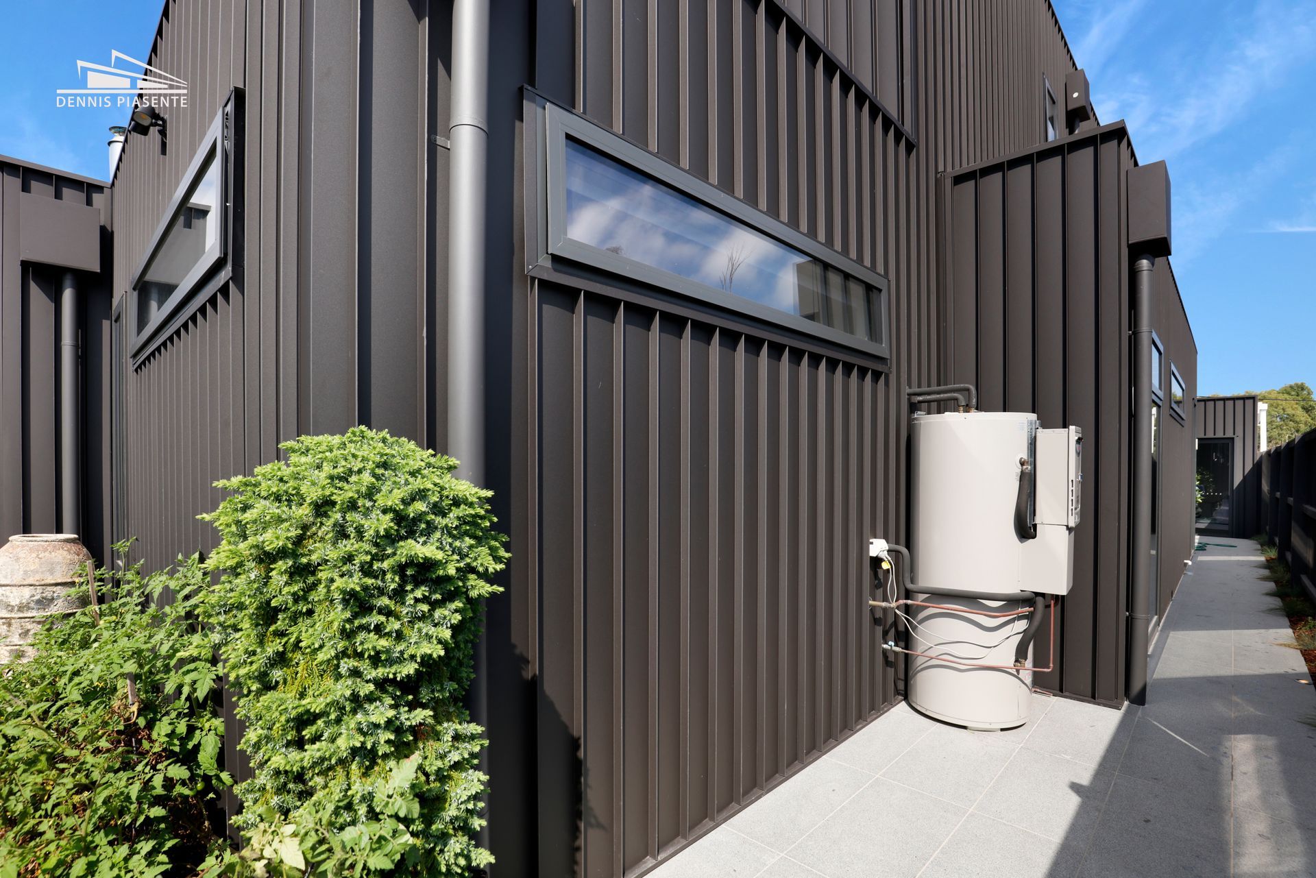 A large black building with a white tank on the side of it.