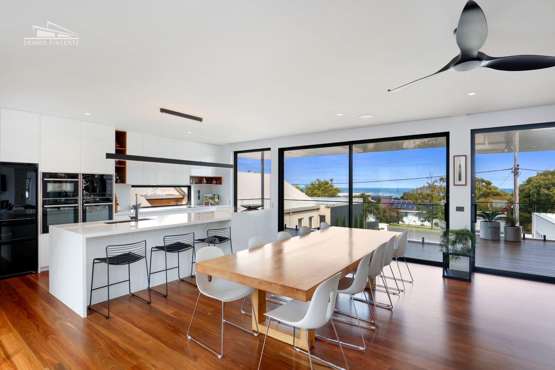 A kitchen and dining room in a house with a large table and chairs.