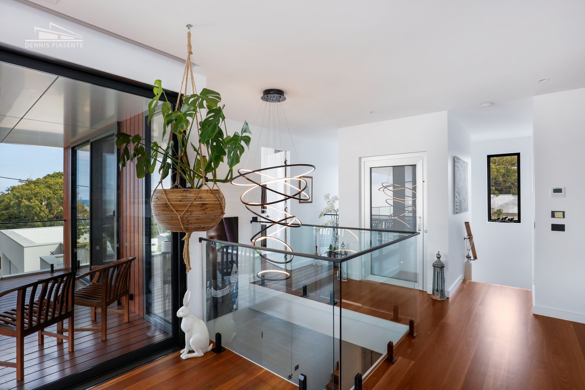 There is a plant hanging from the ceiling in the middle of the room.