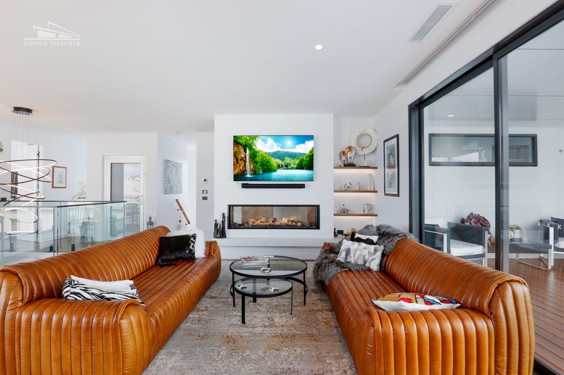 A living room with two brown couches and a flat screen tv