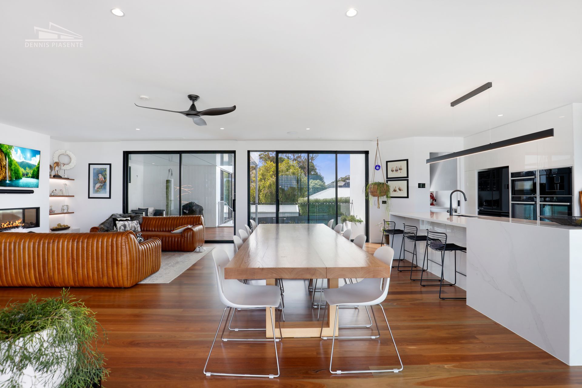 A large dining table is in the middle of a living room.