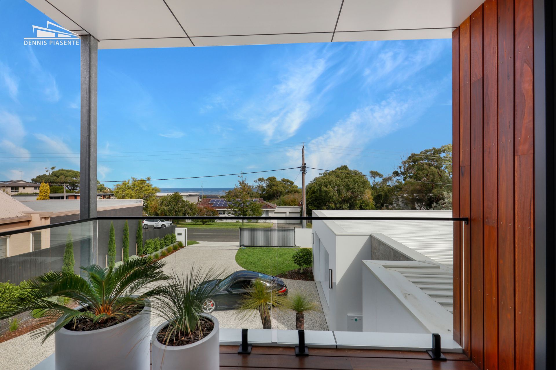 A balcony with potted plants and a view of the ocean