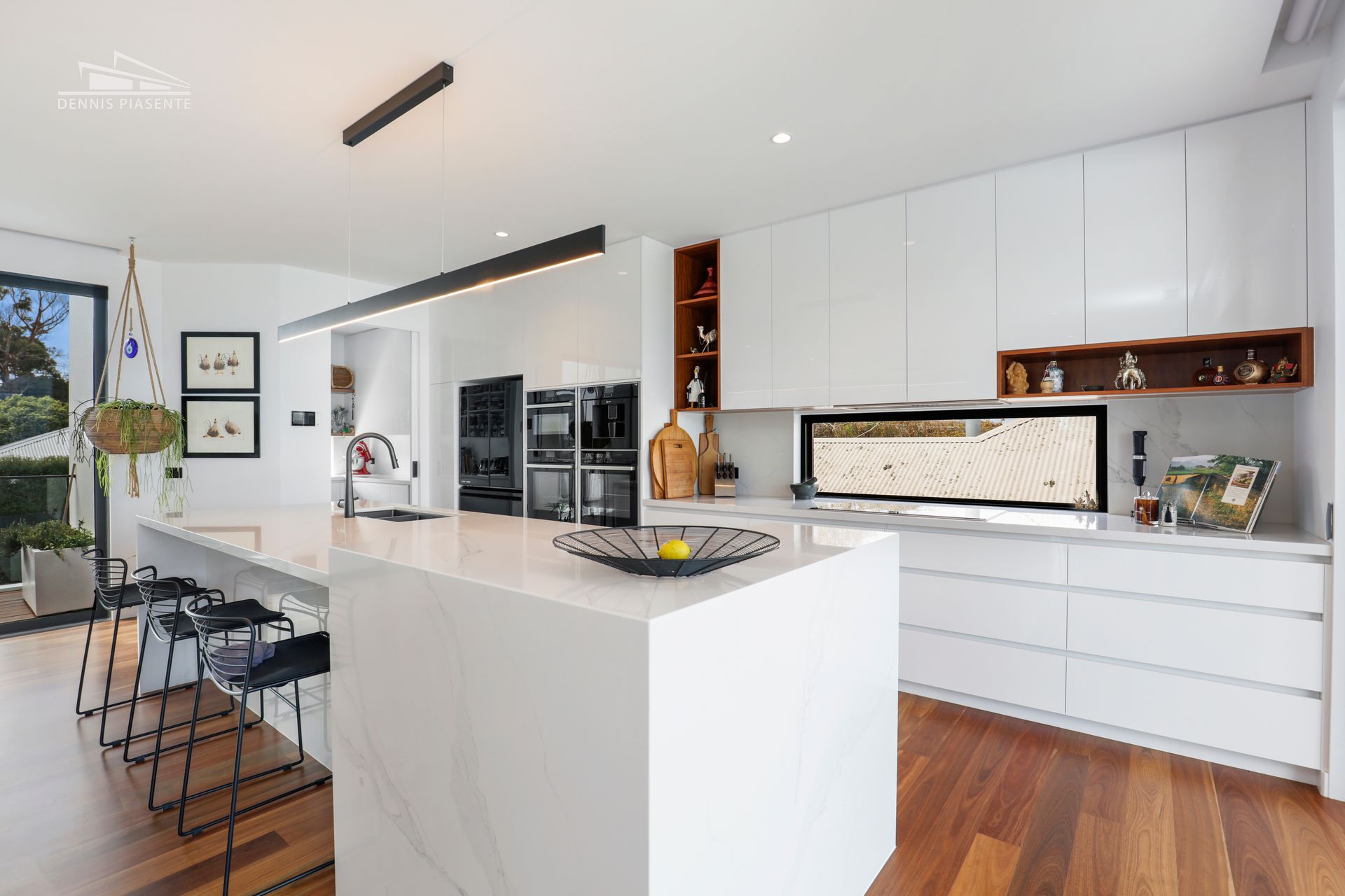 A kitchen with white cabinets and wooden floors and a large island.