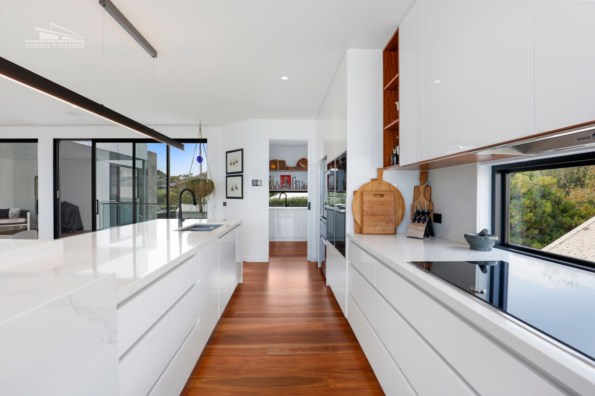 A kitchen with white cabinets and wooden floors