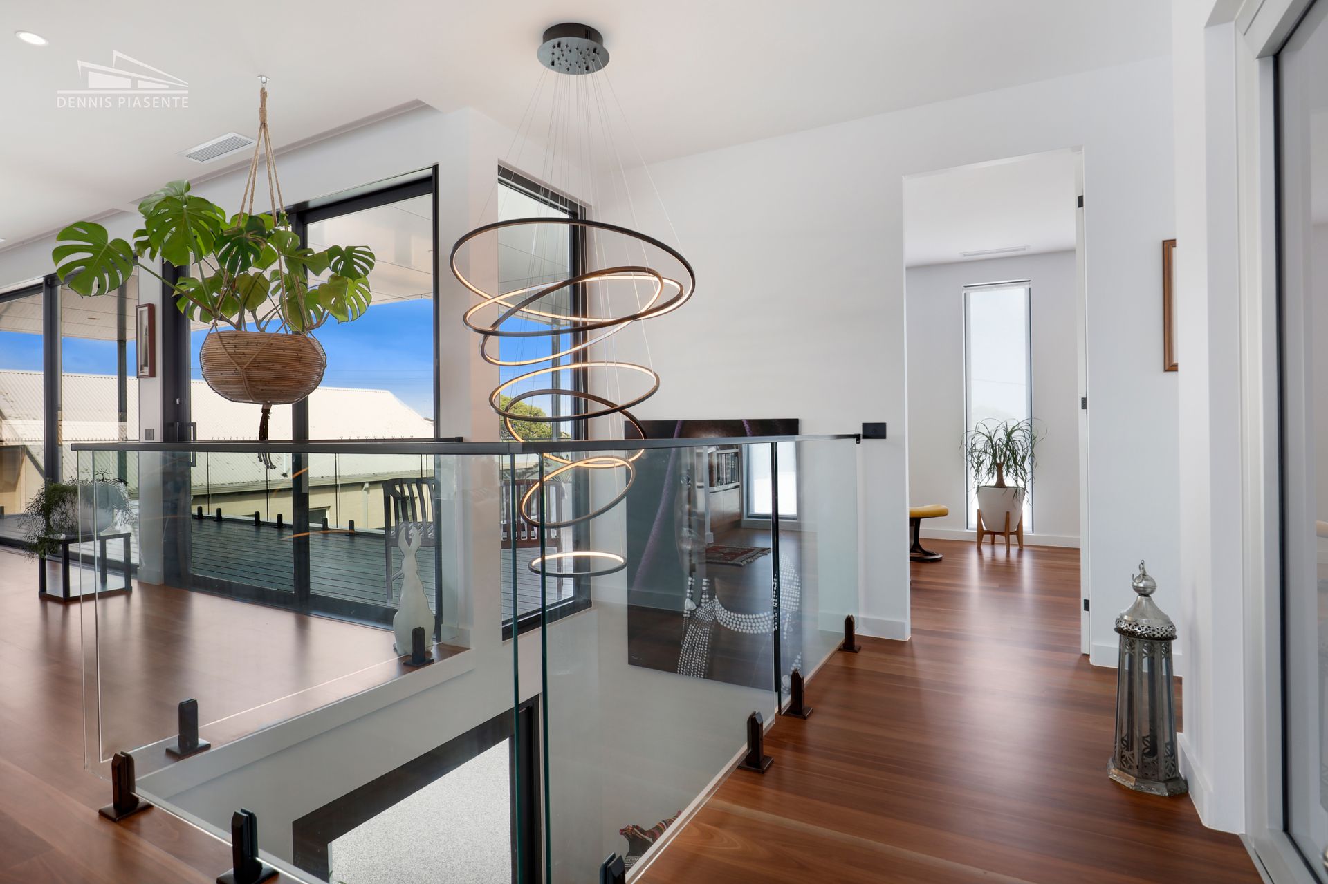 There is a staircase in the middle of the room with a glass railing.